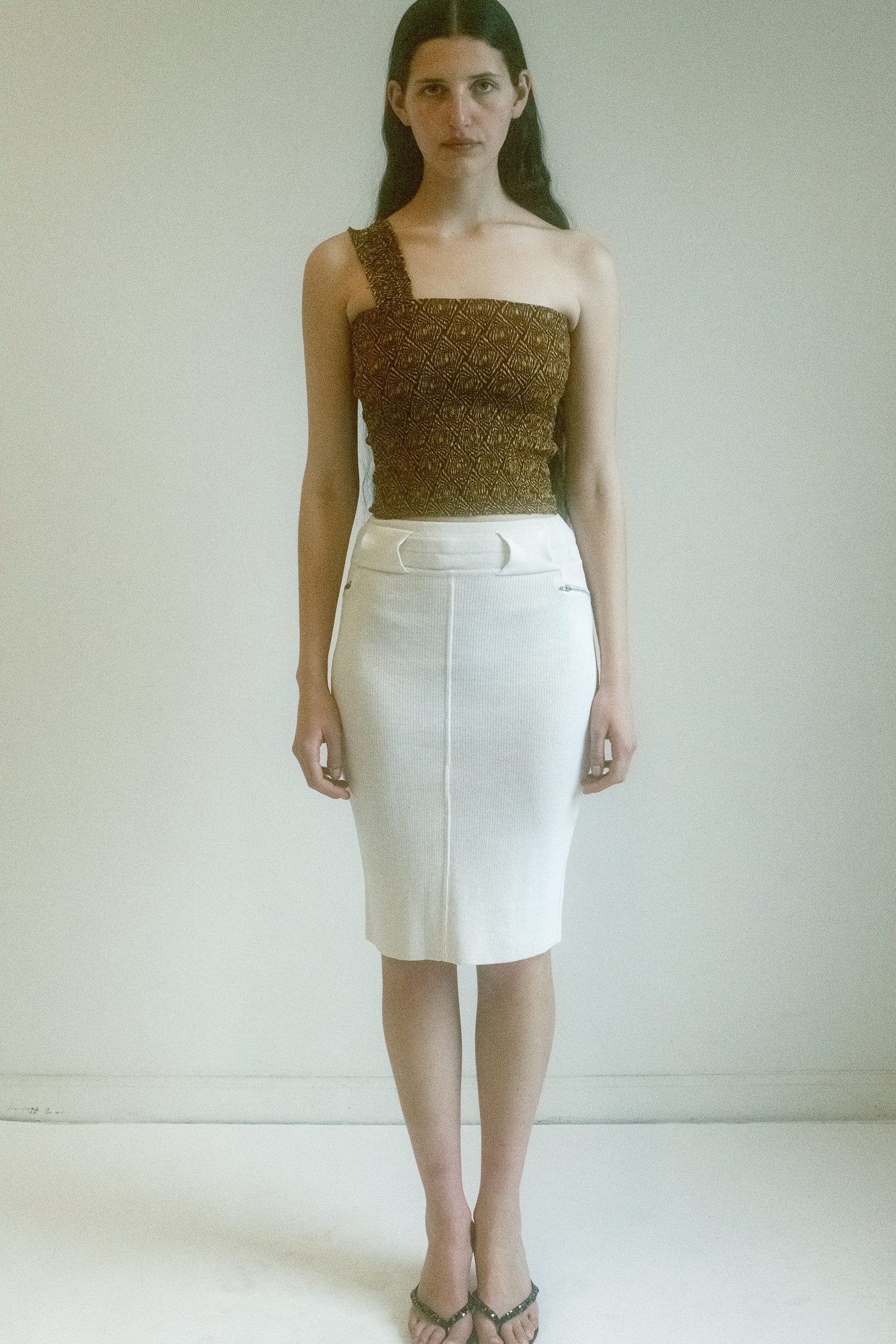 The subtle pattern dances across the fabric, a flirtation of shadow and light, while the one-shoulder detail invites an air of allure, barely contained within the gentle embrace of the smocked fit.