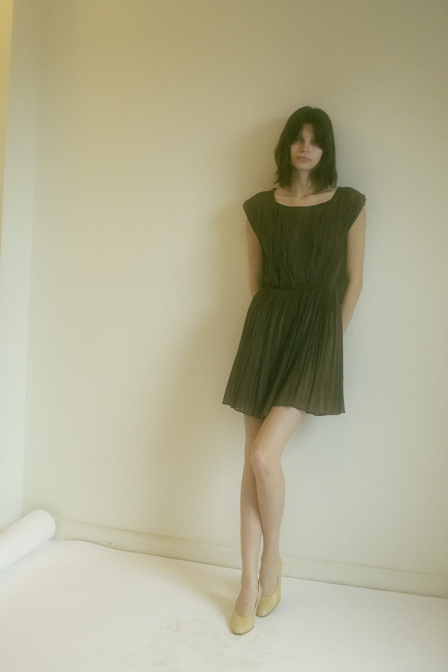 The sheer pleated dress in brown, with its delicate pleats whispering secrets as you move, feels like a scene from a timeless cinematic moment.