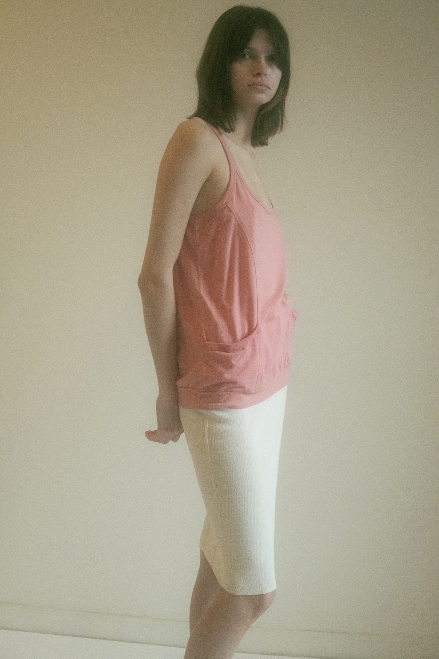 The tank clings with nonchalance, loose and languid, with two front pockets that don’t carry much—just secrets and a half-smoked clove.