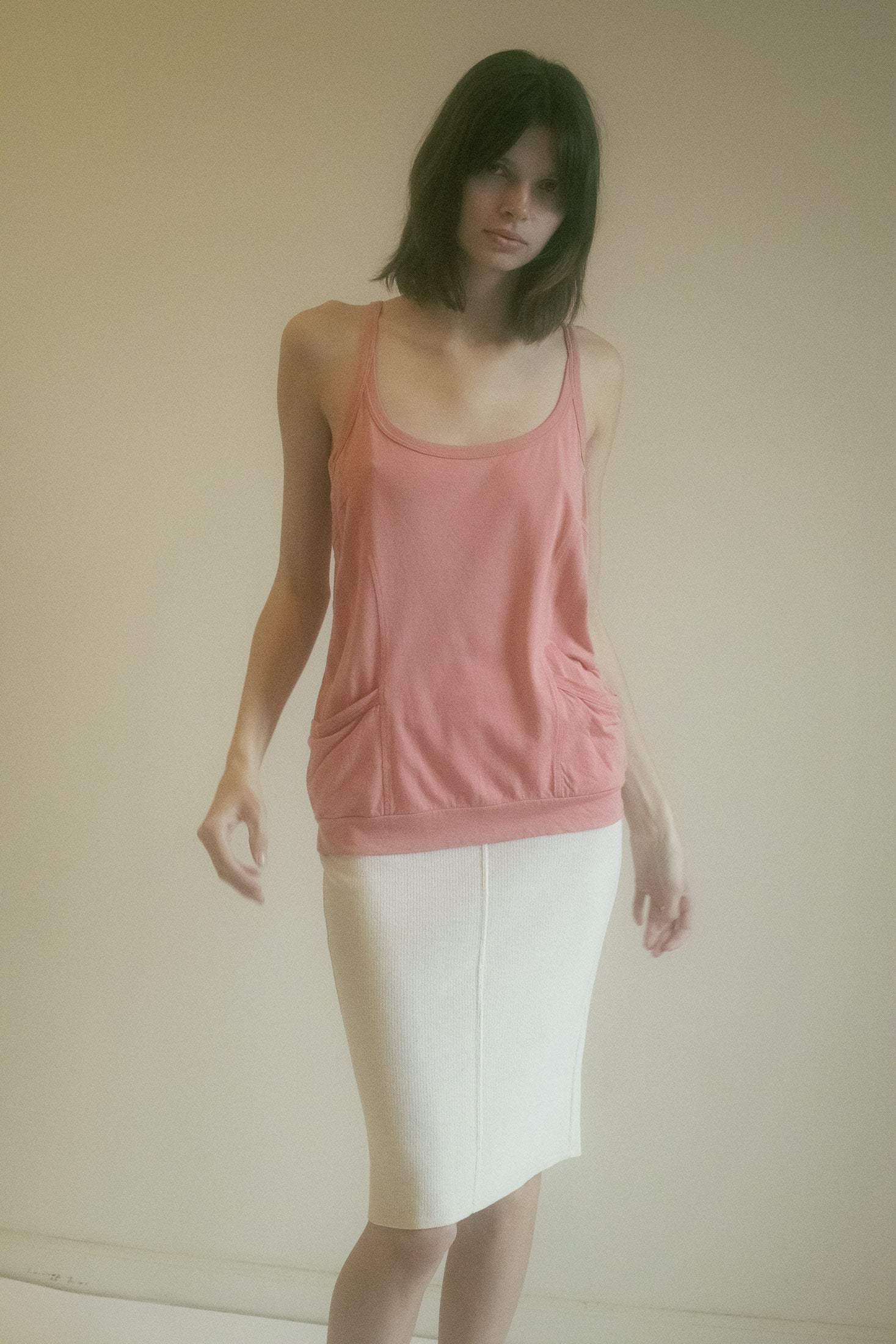 A vintage tank top by Dries Van Noten. Thin spaghetti straps trace her shoulders like lines from a forgotten poem.