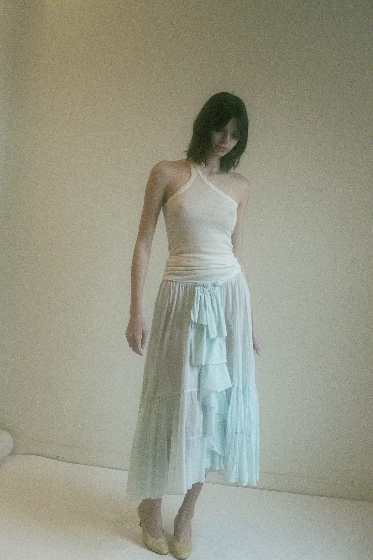The stark white color, contrasts with the bold seam detail that runs down the front—a single line of defiance, a thread of rebellion running through its otherwise serene composure.