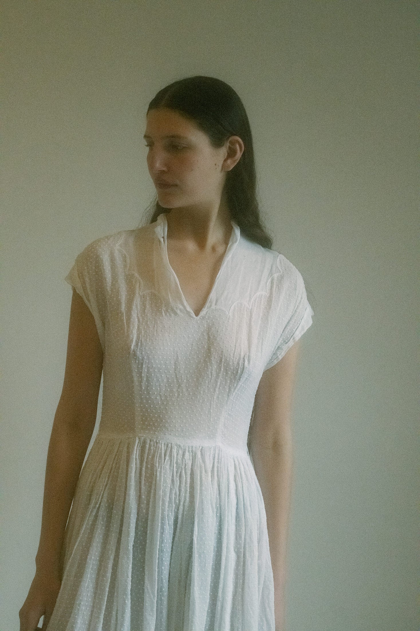 Cap sleeves barely skim the shoulders, leading into a soft V neckline edged with delicate eyelet detail—sweet, but not naïve.