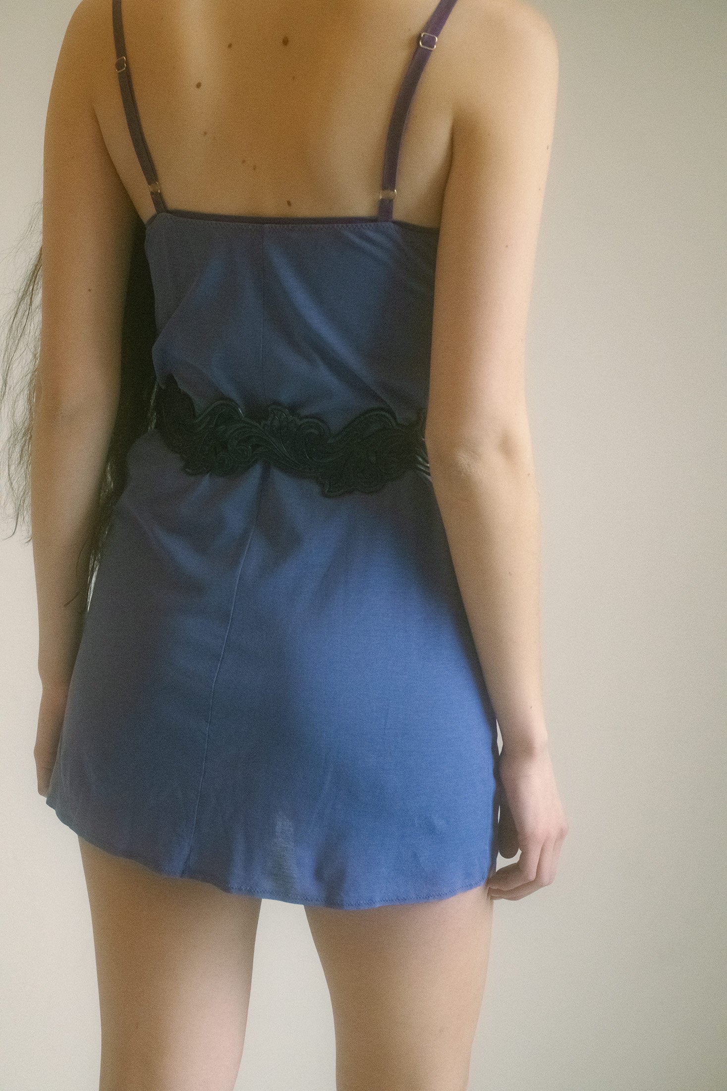 Thin, adjustable straps trace the shoulders with a whisper of delicacy.