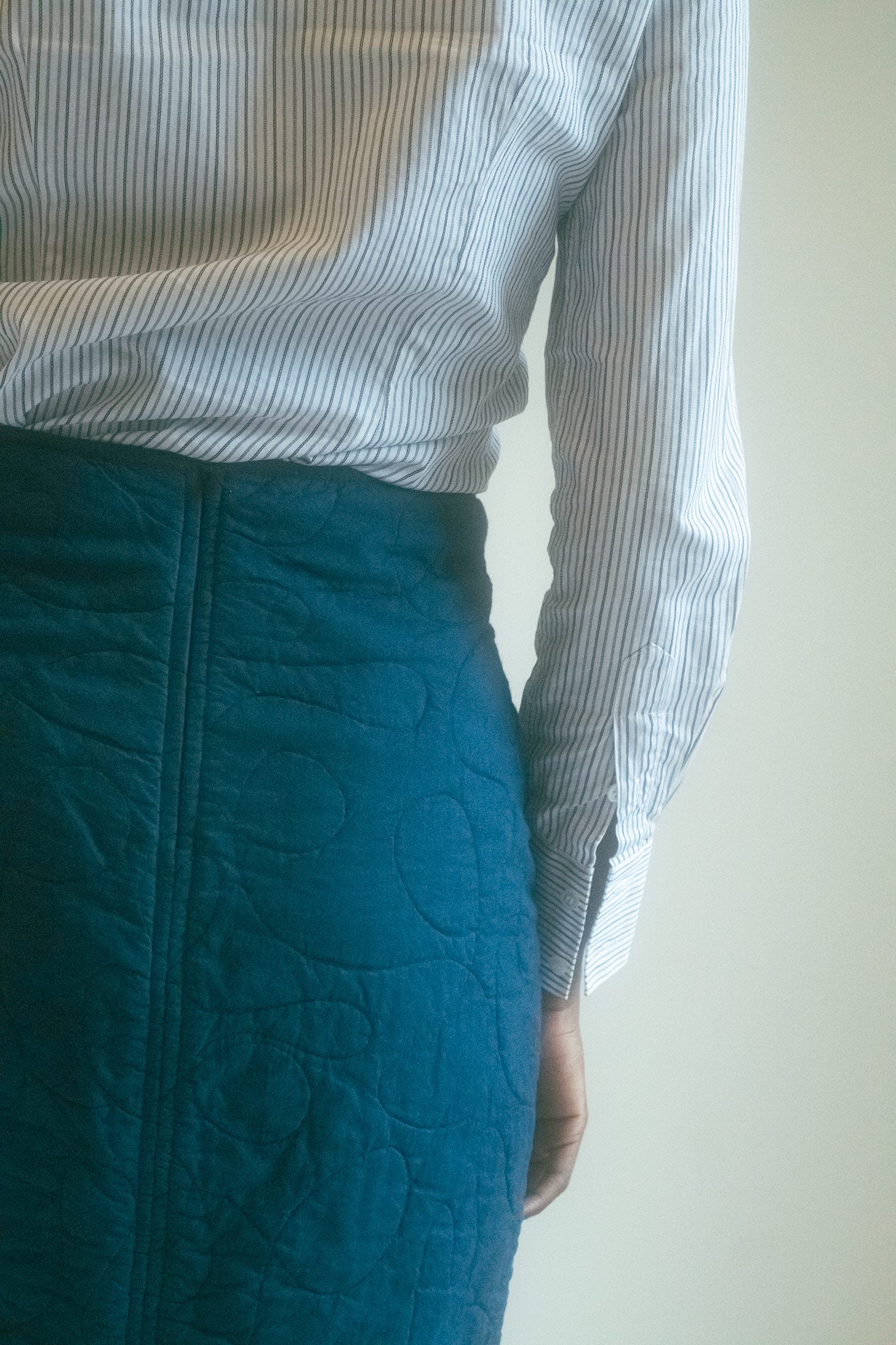 The quilted fabric, with its undulating texture, suggests depth—layers of stories, secrets, and experience.