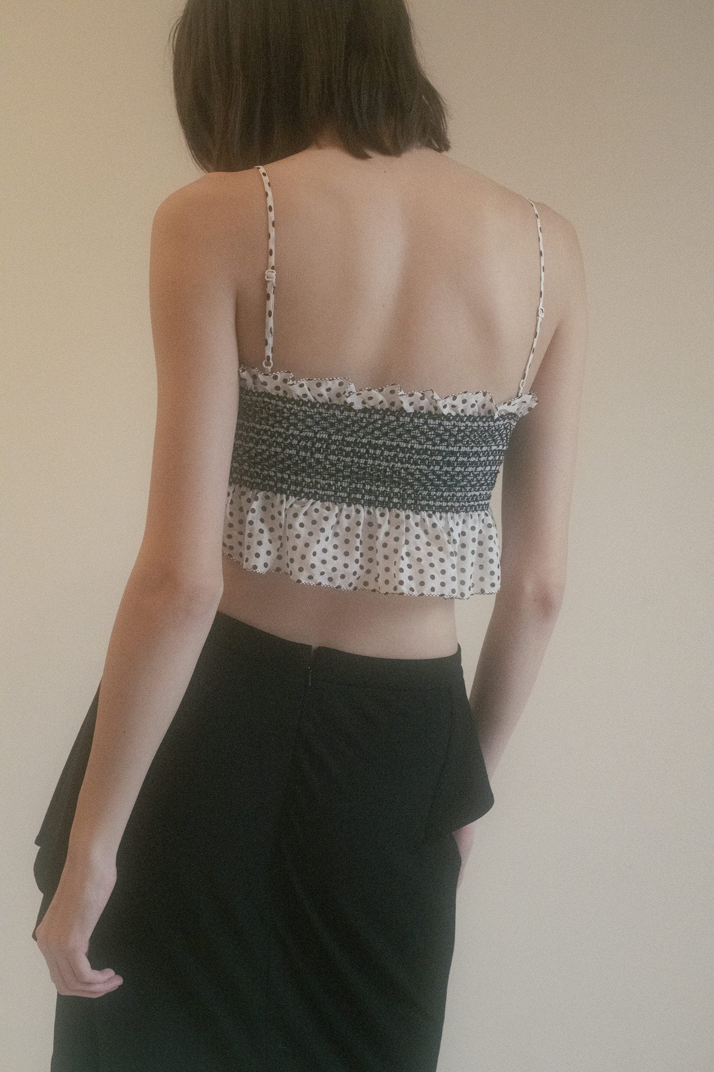 Featuring delicate smocking detail, this crop top hugs the body with a soft, sensual fit, while the polka dot print adds a touch of whimsical elegance.