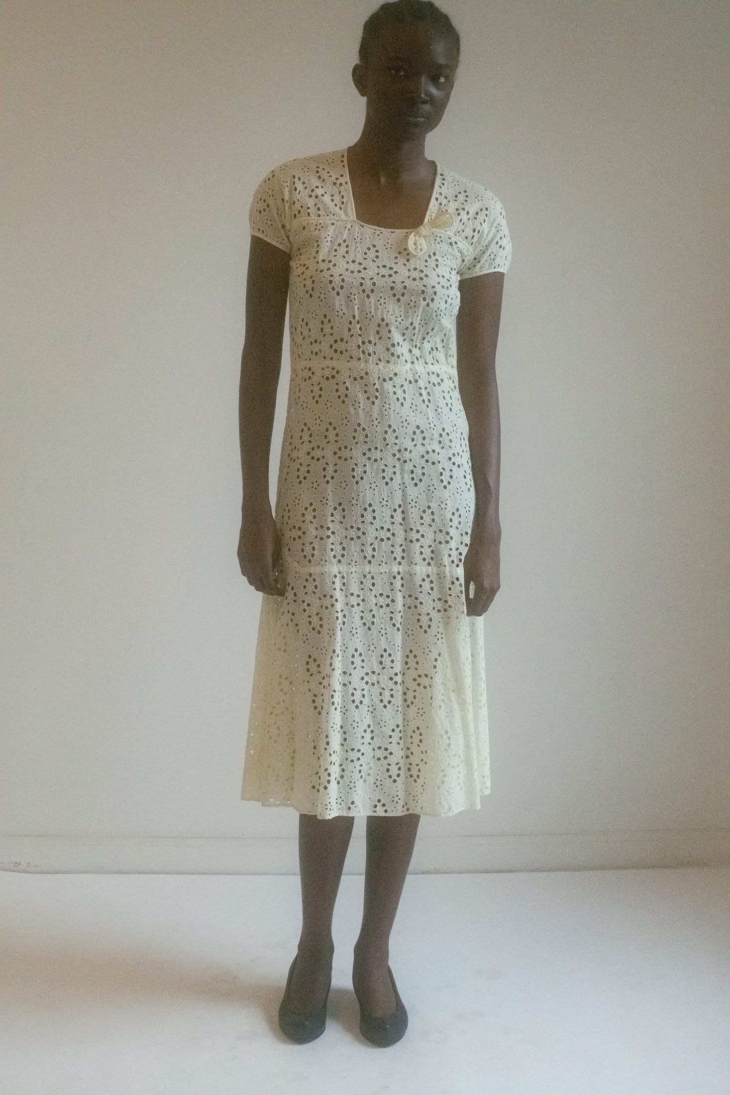 The Antique Eyelet Dress is a masterpiece that blends intricate craftsmanship with timeless elegance.