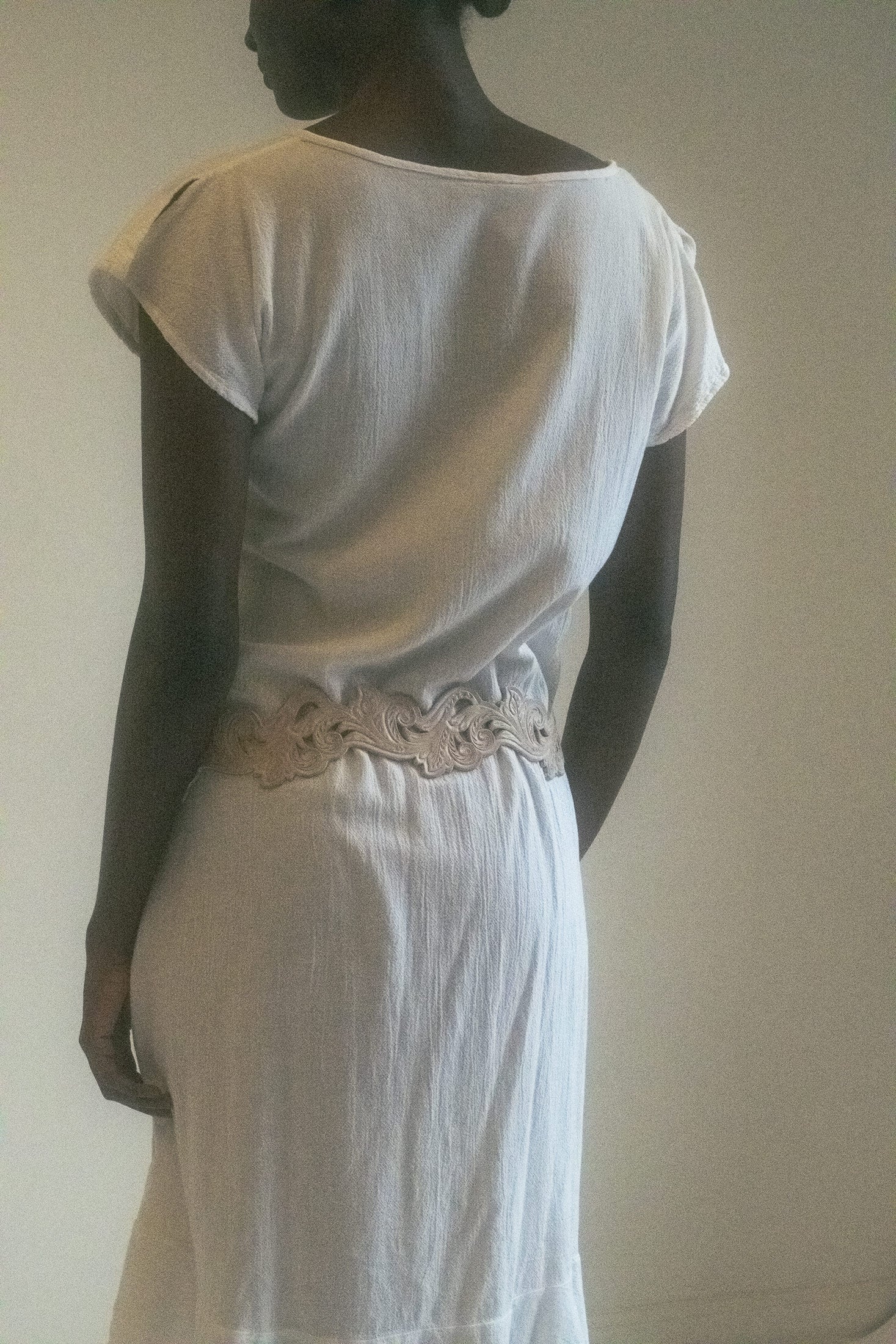 Its short sleeves and sheer fabric create a soft, ethereal vibe, while the asymmetrical hem brings a unique, avant-garde touch that sets it apart.