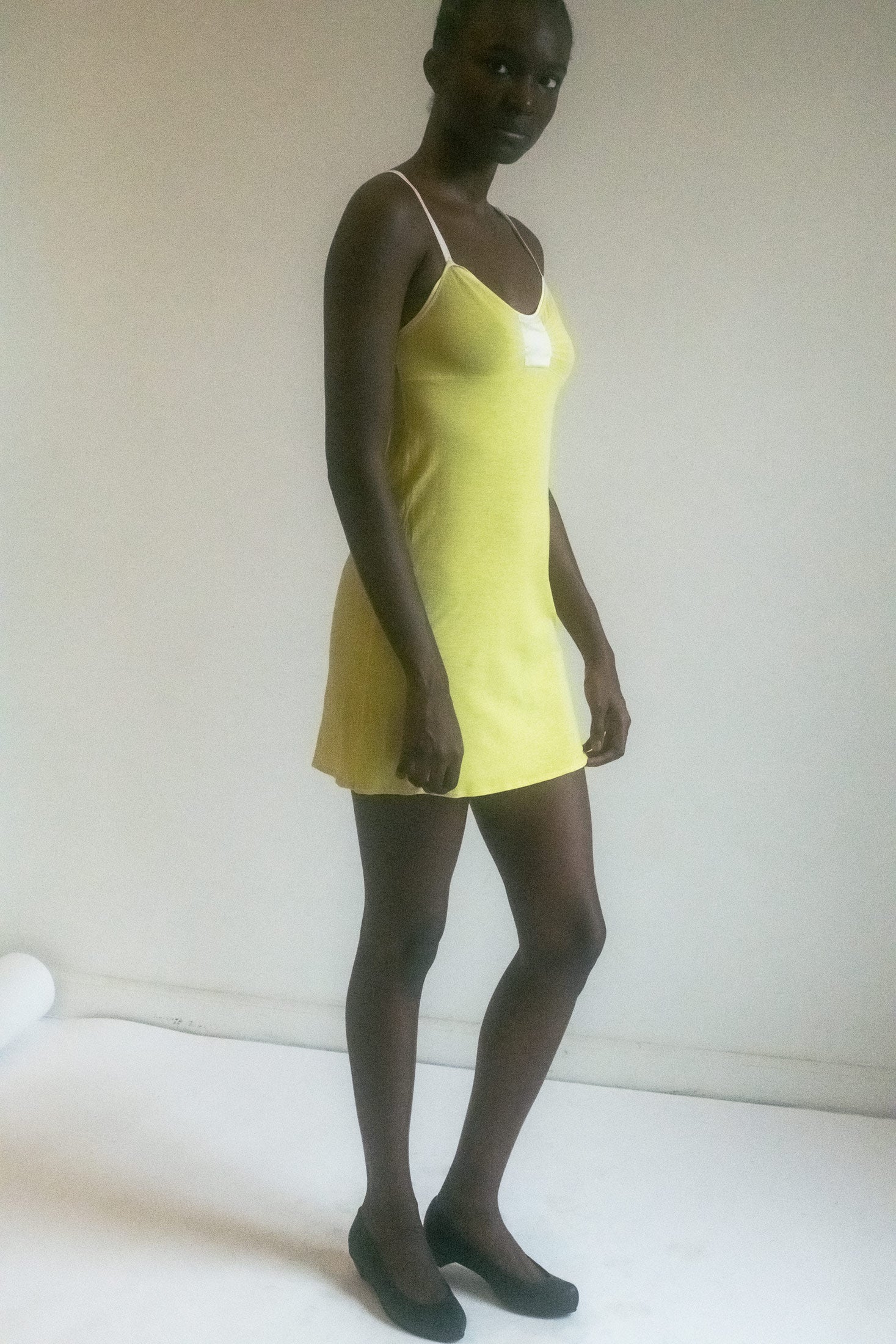 The canary yellow fabric dances with warmth, a hue that evokes the soft caress of sunlight on bare skin.