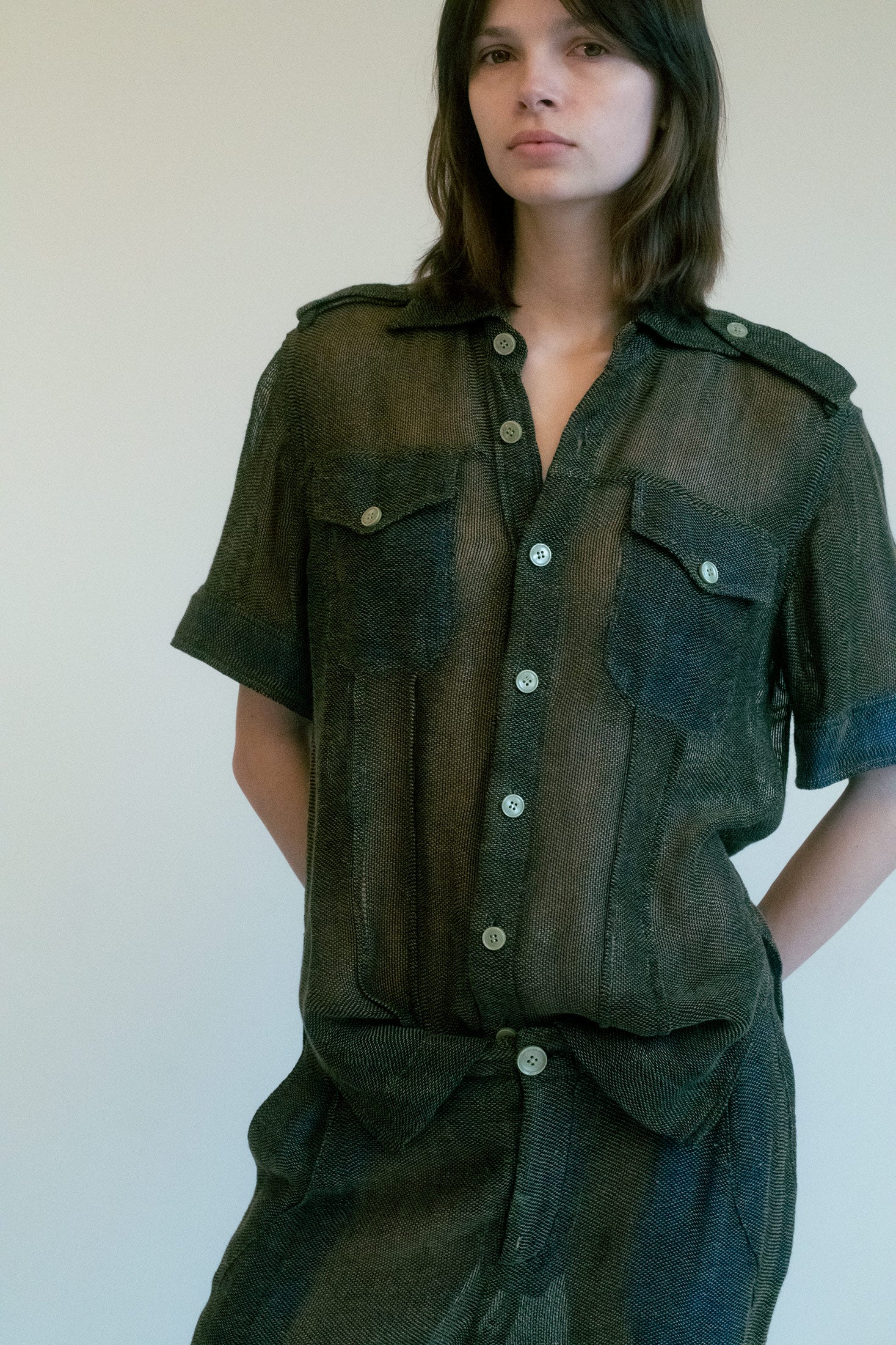 Linder's short-sleeved button-down shirt is a symphony of subtle seduction, where military-inspired details meet a whisper of sensuality.