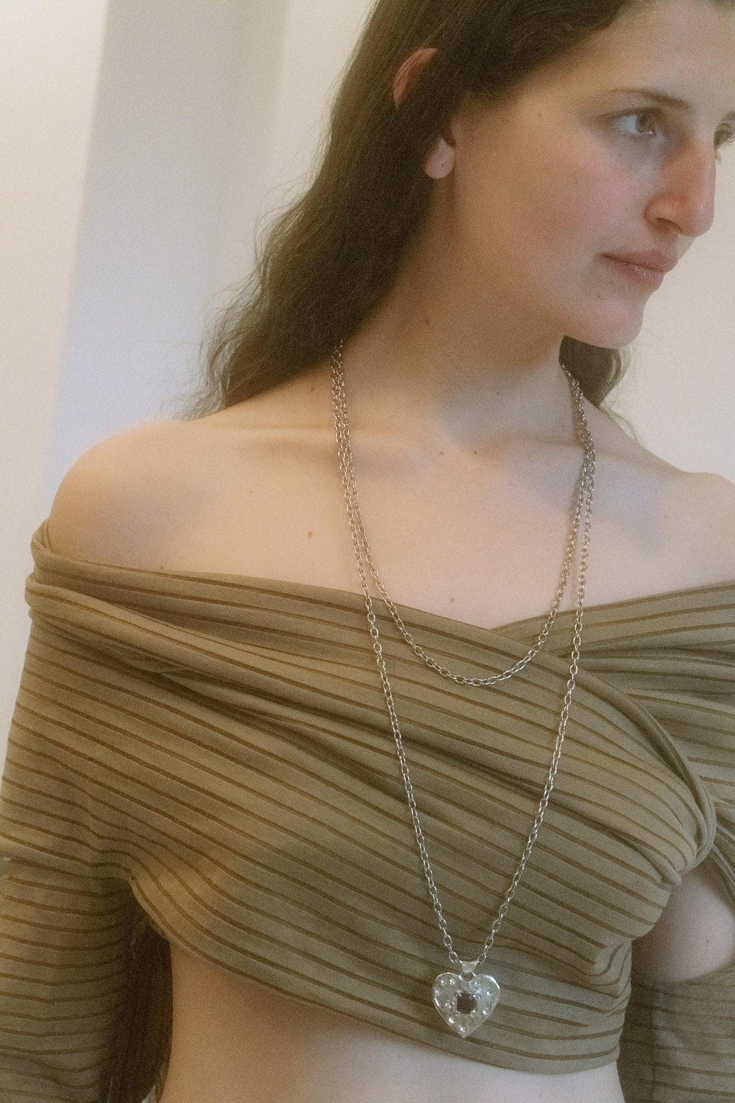 Crafted in sterling silver, the link chain glides effortlessly along the neckline, securing with a clasp fastening.