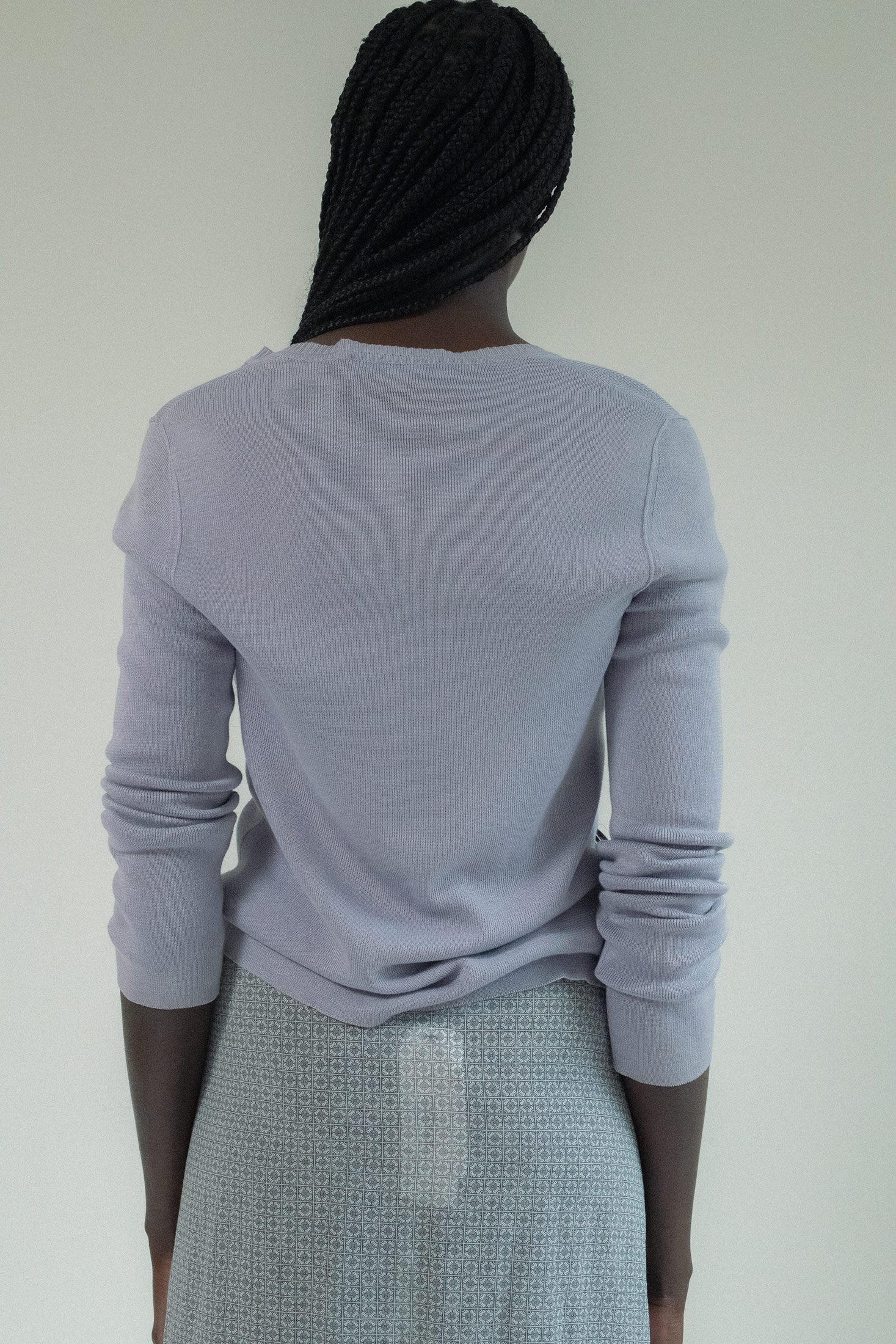 The long sleeves and crewneck style whispered of timeless beauty, but it was the ruffle pocket details that held your gaze, a playful touch that hinted at something deeper, something forbidden.