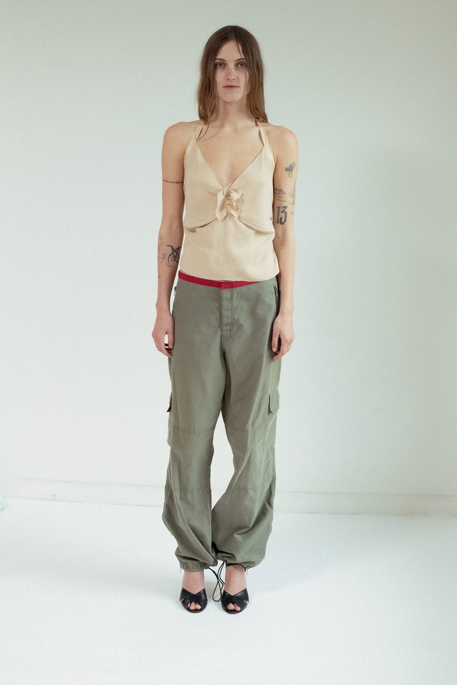 Rendered in a rich olive tone and accented by striking red details, these mid-rise cargos are crafted for both function and flair.