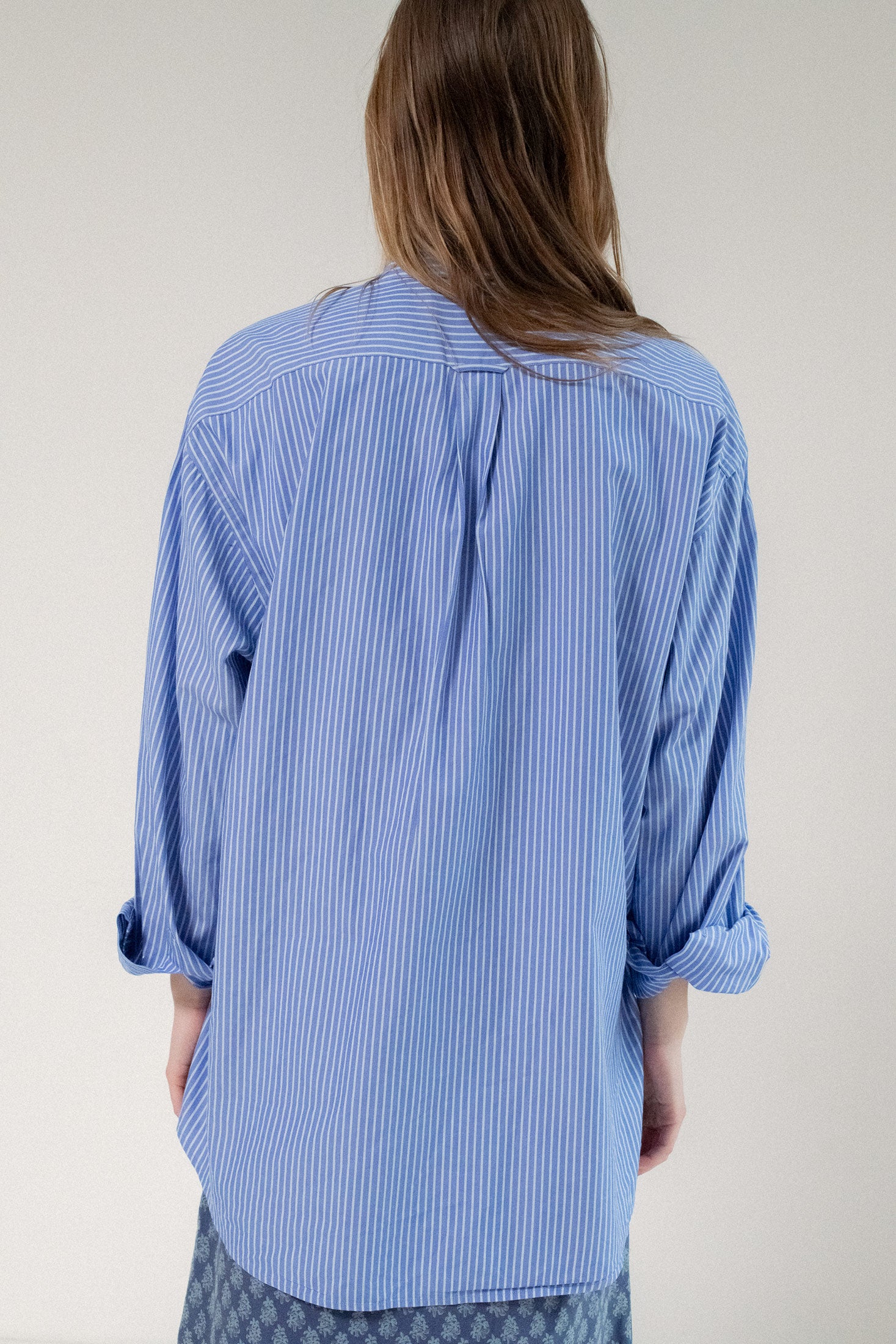 Long sleeves cascade gracefully, offering versatility in styling—whether tucked in for a refined look or left flowing freely for a more relaxed feel.