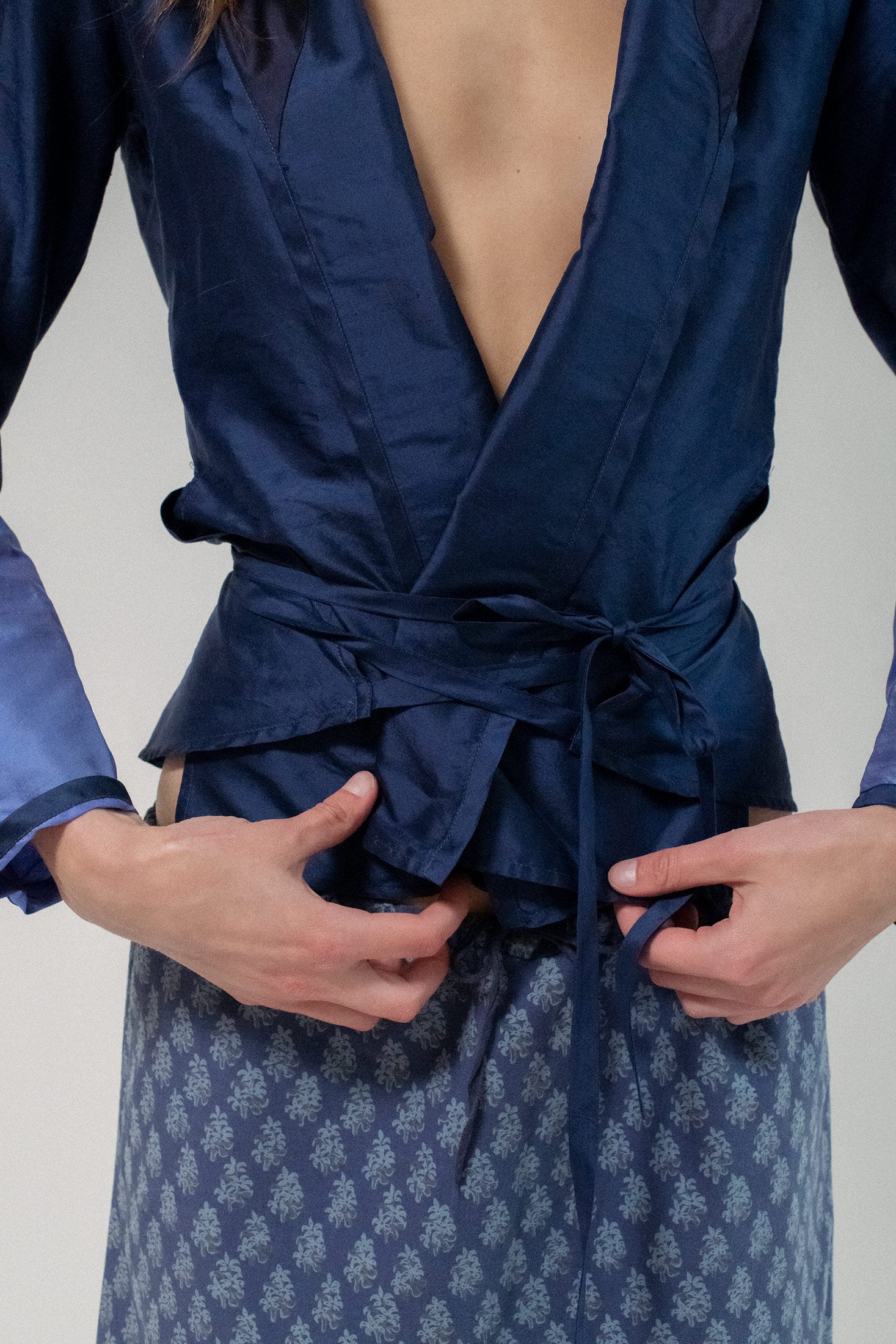 Crafted in dark navy with light blue colorblocking along the sleeves, this wrap-style silhouette is as bold as it is refined.