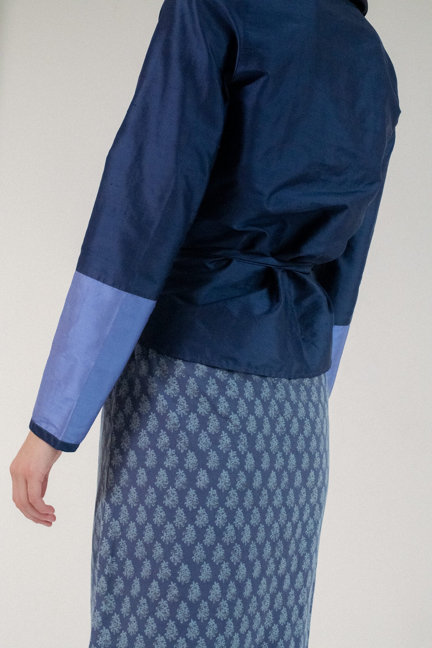 Long sleeves glide softly along the skin, offering just enough structure to anchor its ethereal presence.
