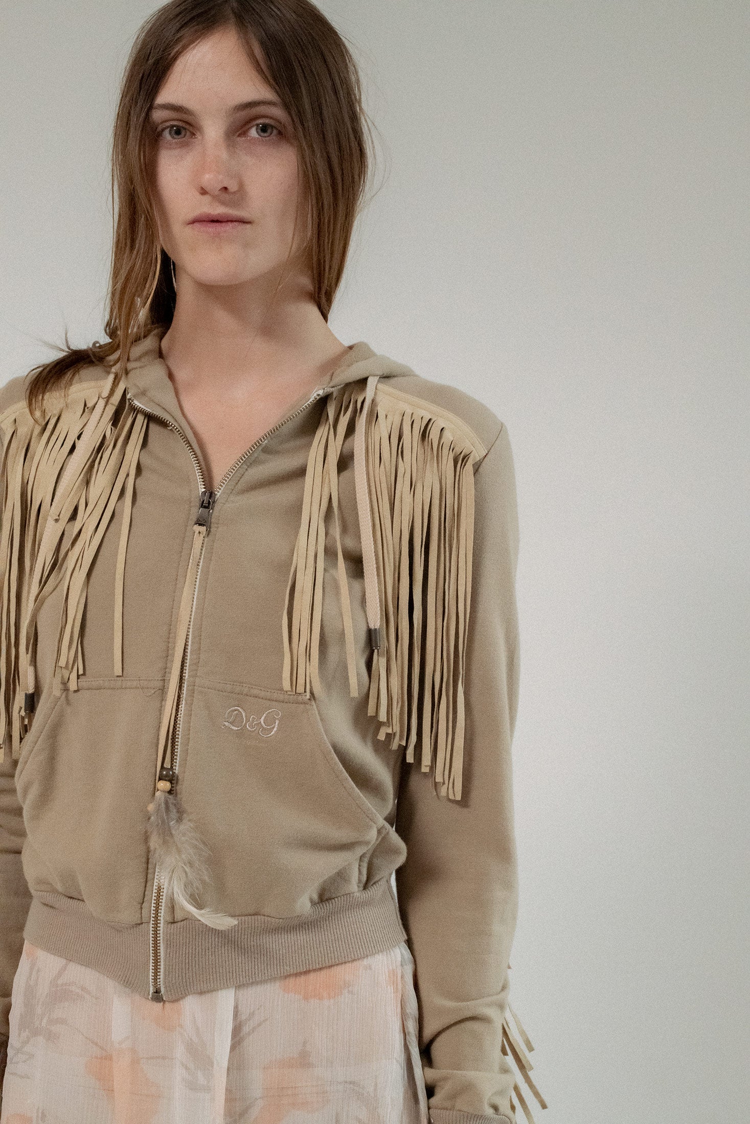 The long sleeves and hoodie detail ground the piece in everyday ease, but its impact is anything but ordinary.