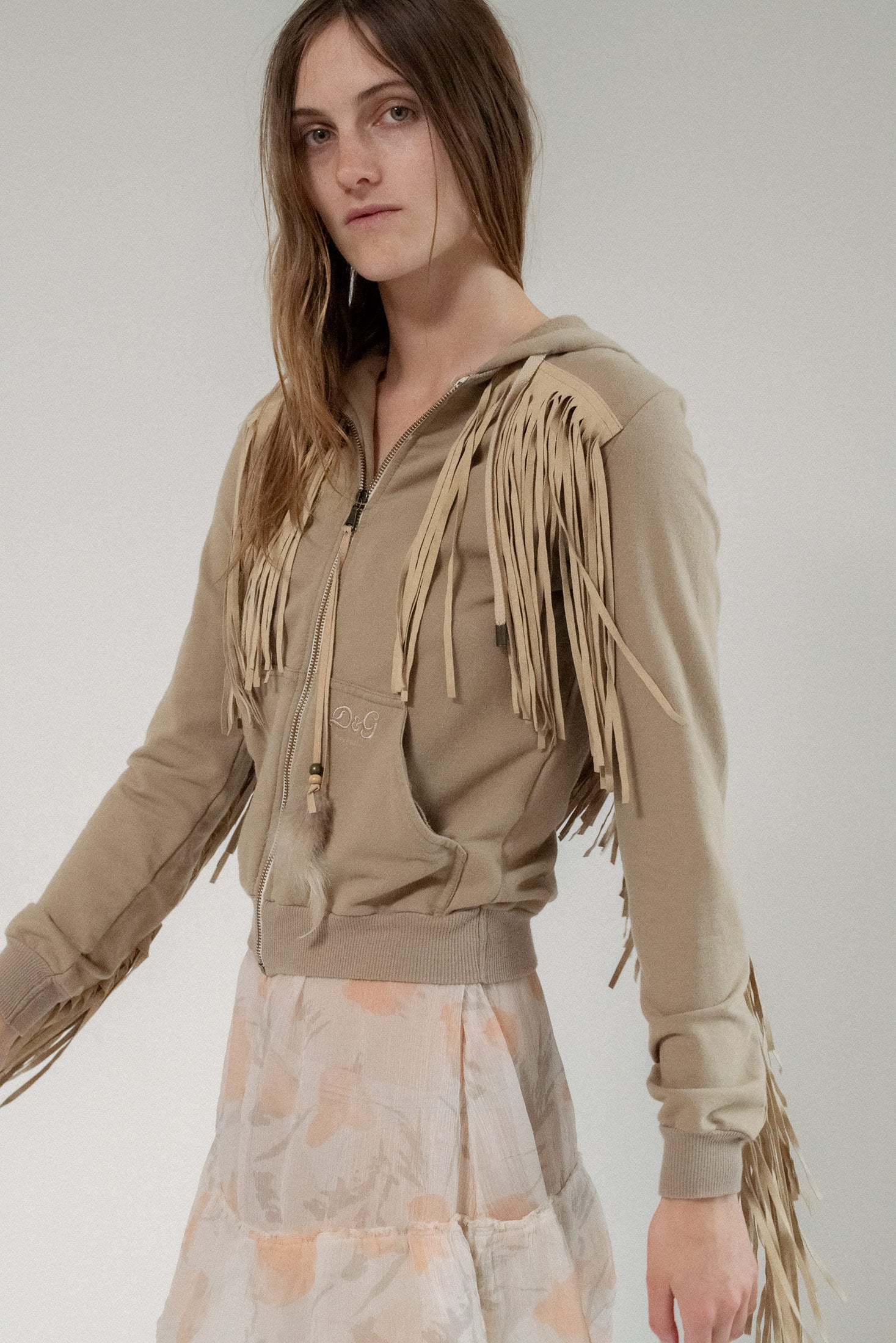 In a rich tan tone, this fitted silhouette hugs the body with confidence, while suede fringe details cascade with effortless drama.