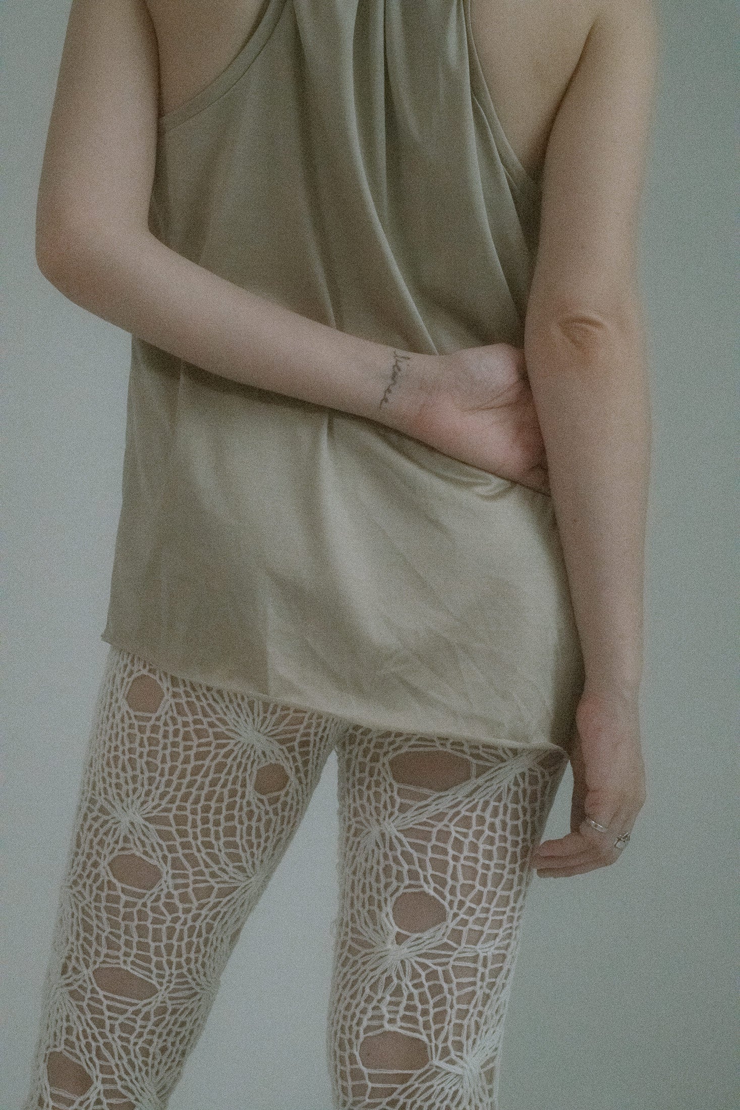 Crafted from glossy knit jersey with a faint sheen, its champagne tone plays the role of innocence while the cut tells another story.