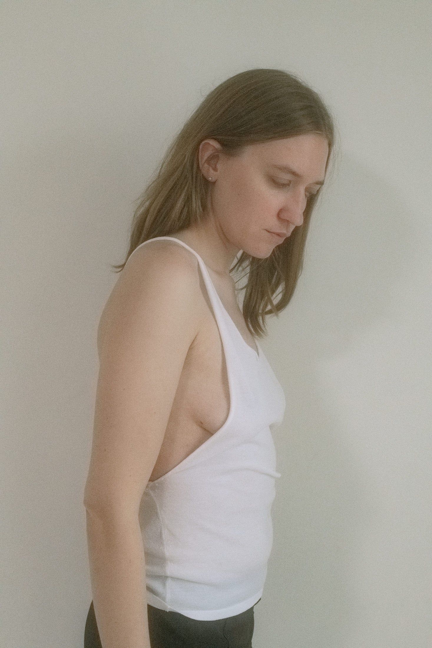 Thin straps frame the shoulders before giving way to an open back with an artful twist—like something slipped on after midnight and never taken off.