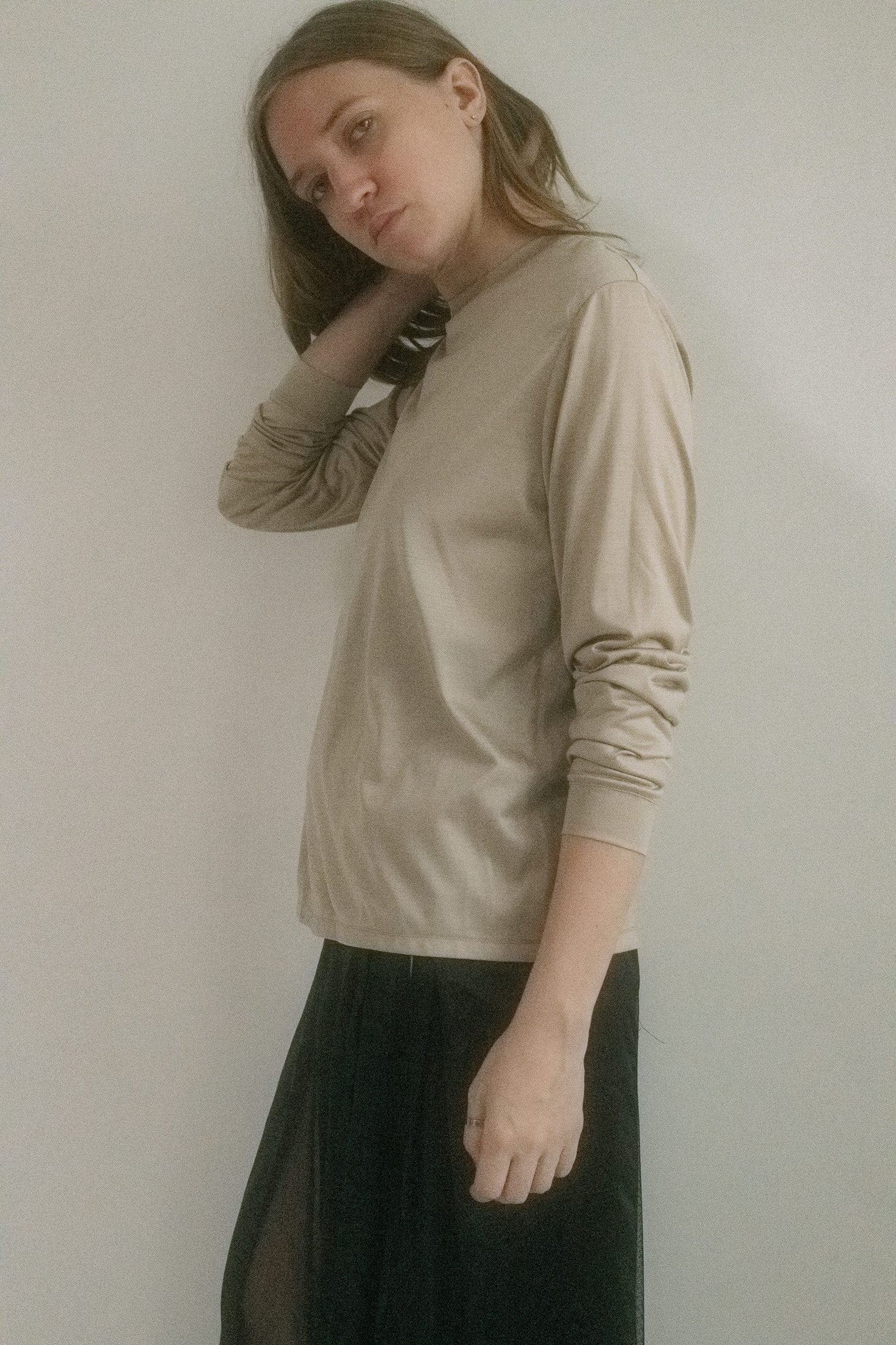 Cut from a slinky knit jersey with a subtle sheen, this long sleeve crewneck shimmers in a soft champagne tone, like moonlight caught in fabric.
