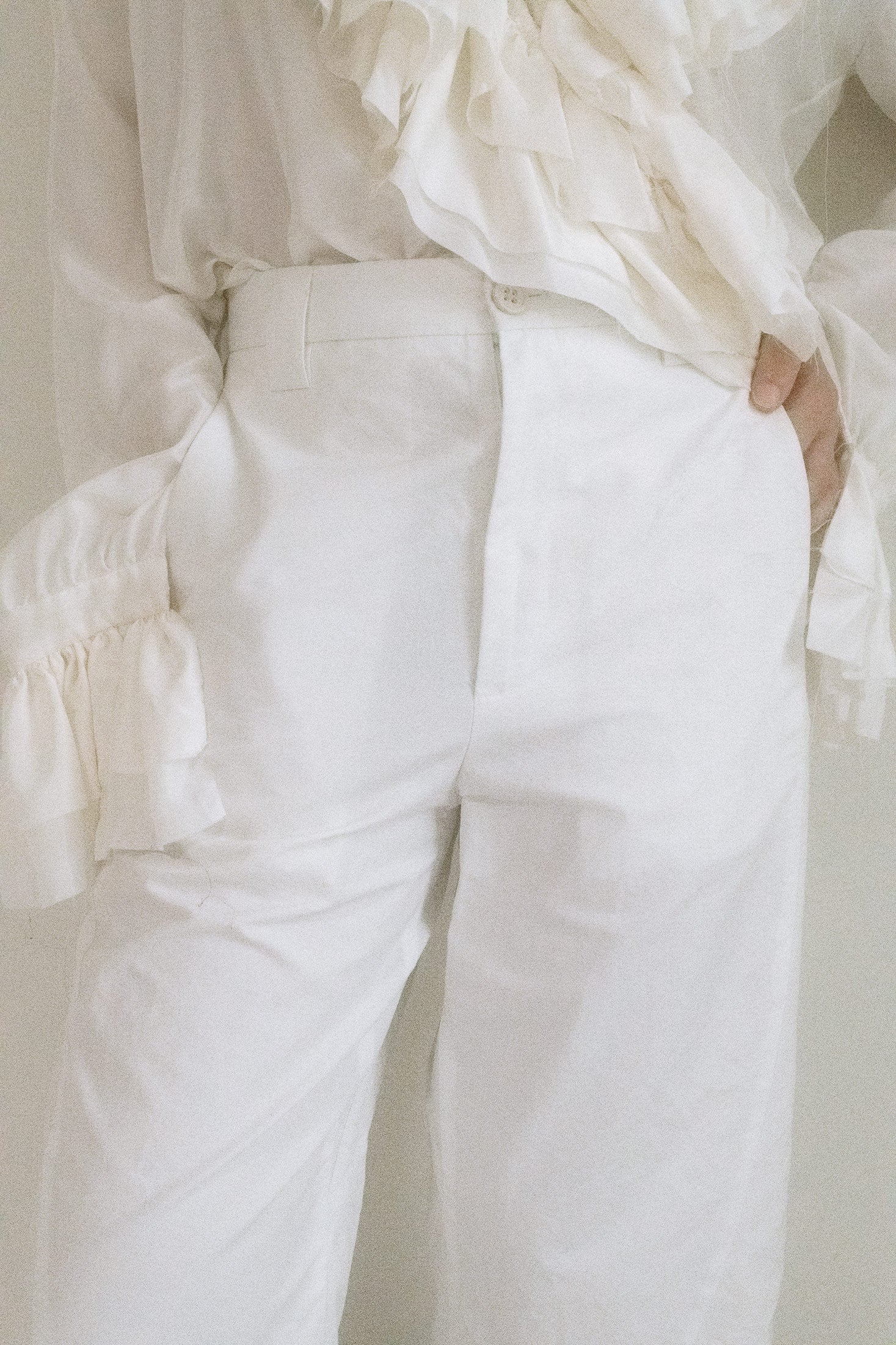 The zip fly and single button closure offer a clean front, but it’s the lace-up detail at the center back that pulls you in, a secret invitation just out of reach.