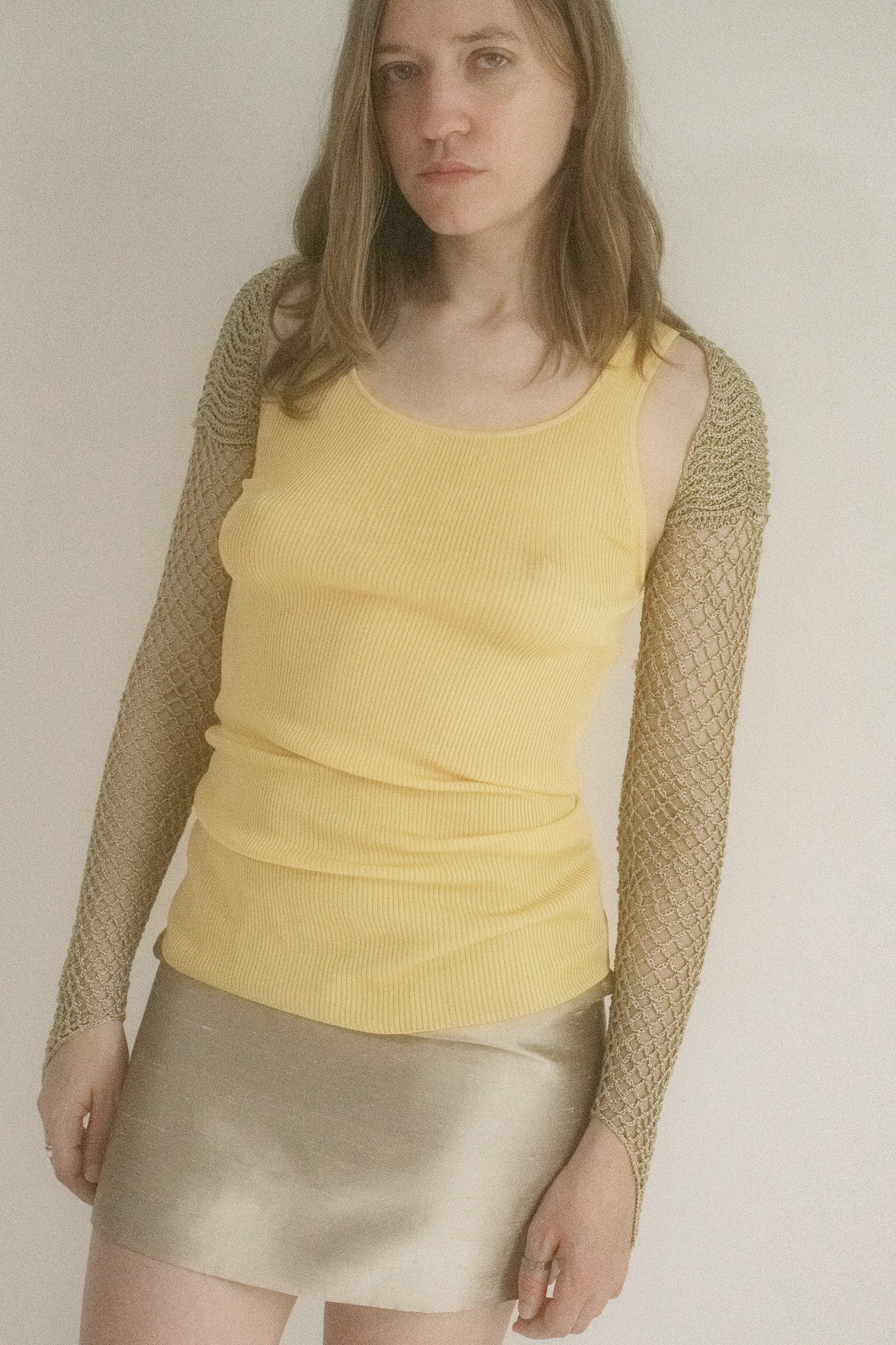 This semi-sheer crochet bolero from Judy Turner is spun in a golden straw hue that glows like candlelight on lacquered skin.