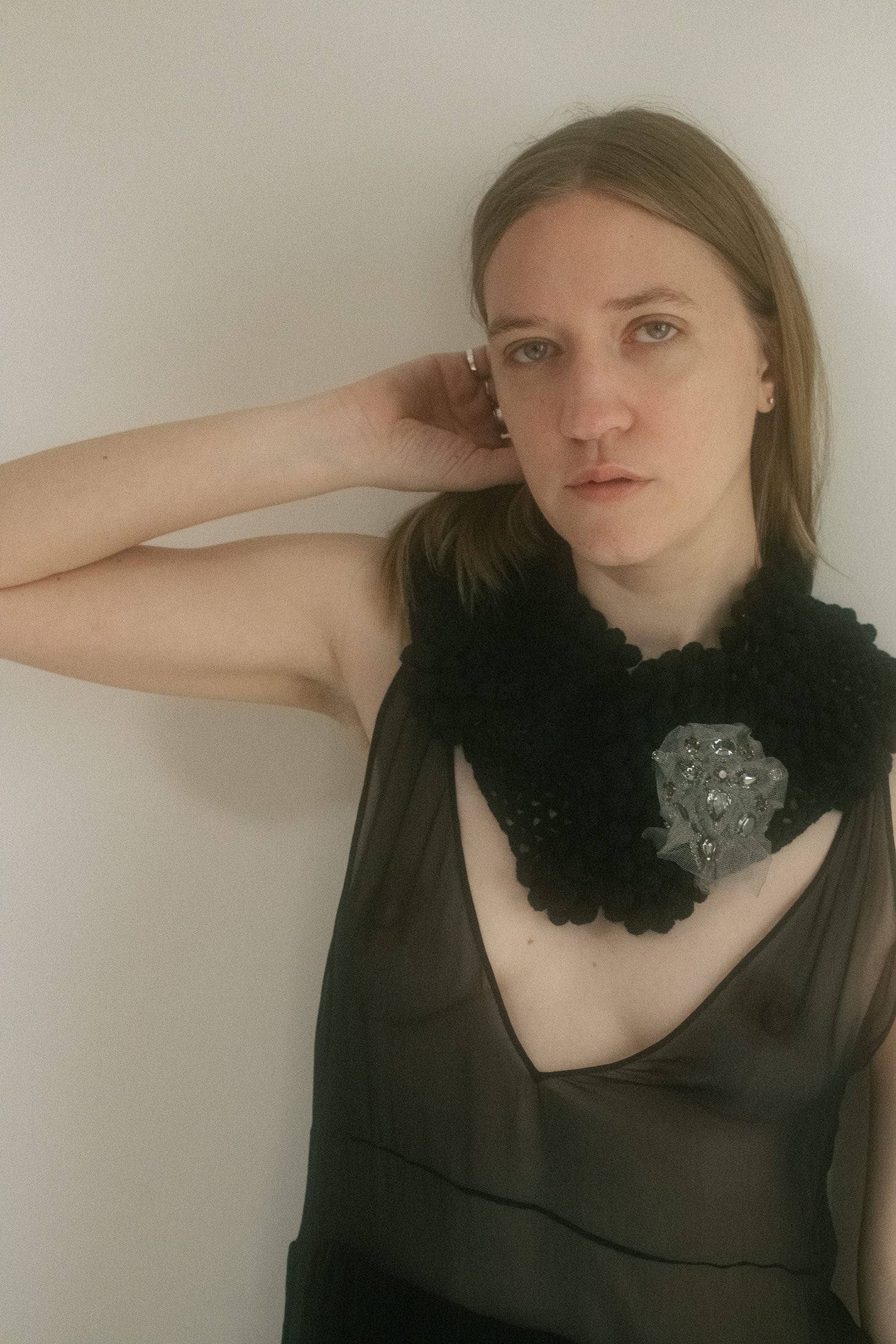Hand-crocheted in a rich black hue and laced with textured detail, it blurs the line between accessory and armor.