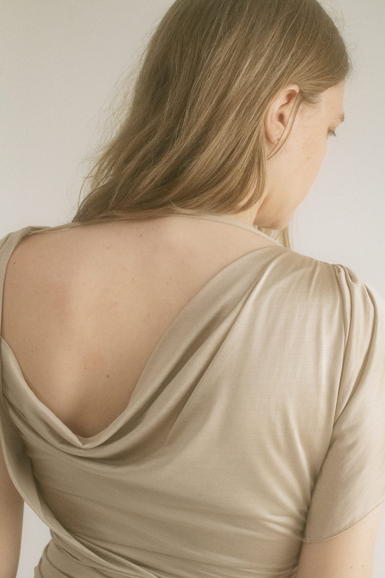Panels of sheer chiffon flicker at the skirt and neckline, catching light—and suspicion.