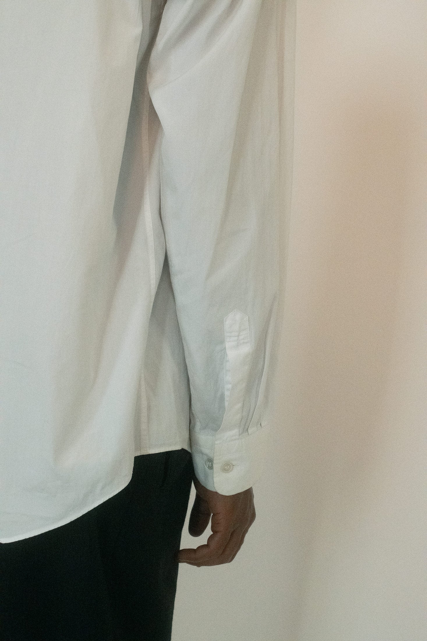 A banded collar sharpens the silhouette - removing excess, leaving only form and clarity.