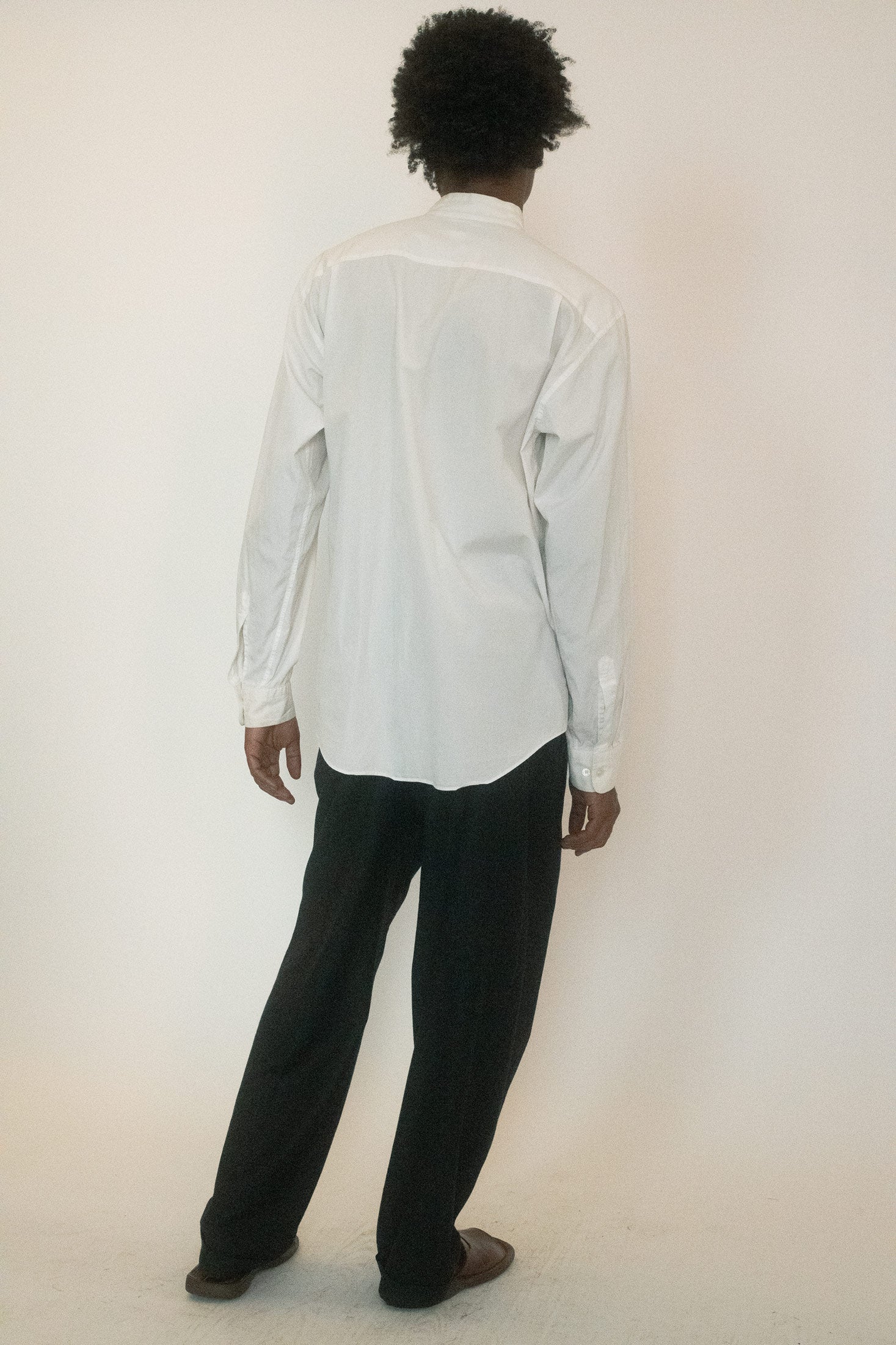 This Issey Miyake button down arrives in classic white, pared back to its essence with tonal buttons that dissolve into the fabric’s surface.