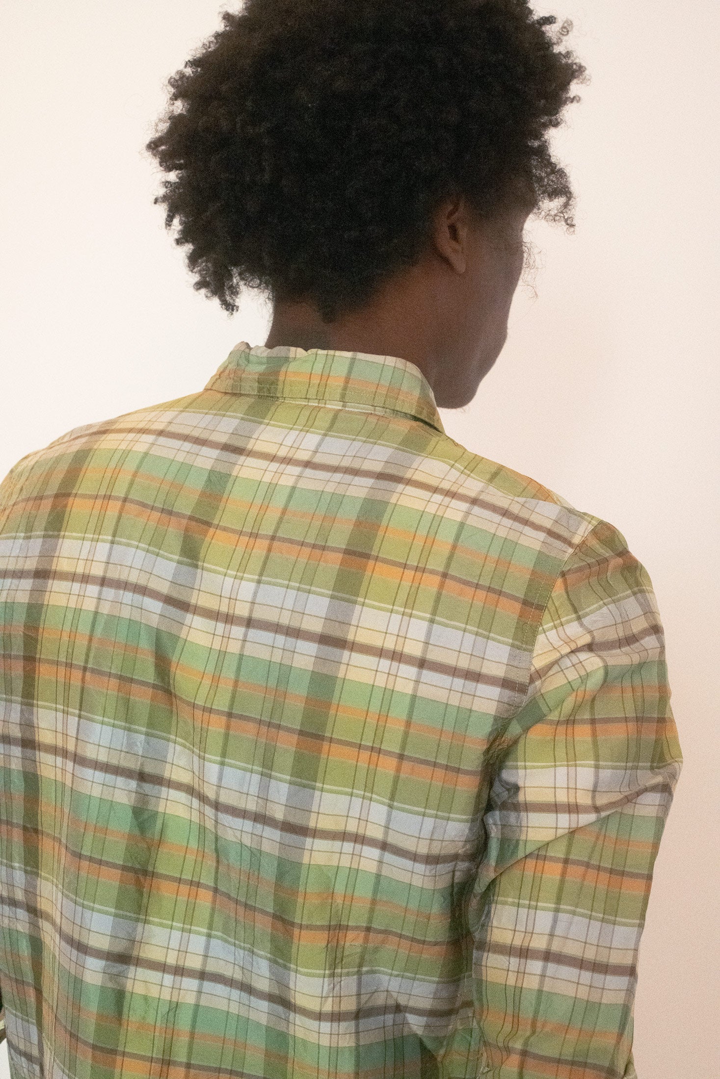 The collared neckline and button front keep the shape precise, yet the drape of silk shifts it into something looser, more fluid, never quite behaving like a standard shirt.