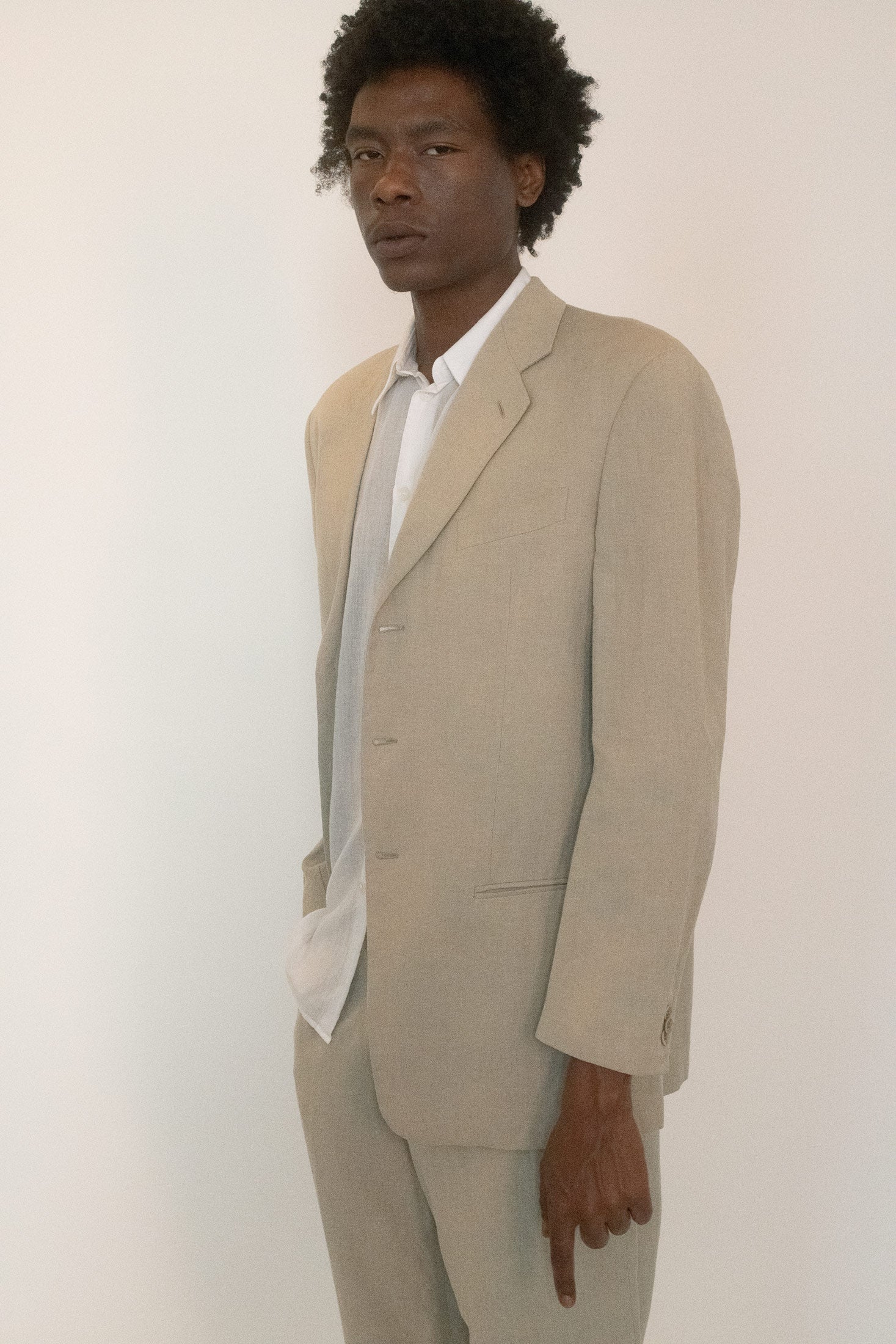 Lined and shaped with a relaxed silhouette, the jacket falls in a tan shade that feels both neutral and cinematic.