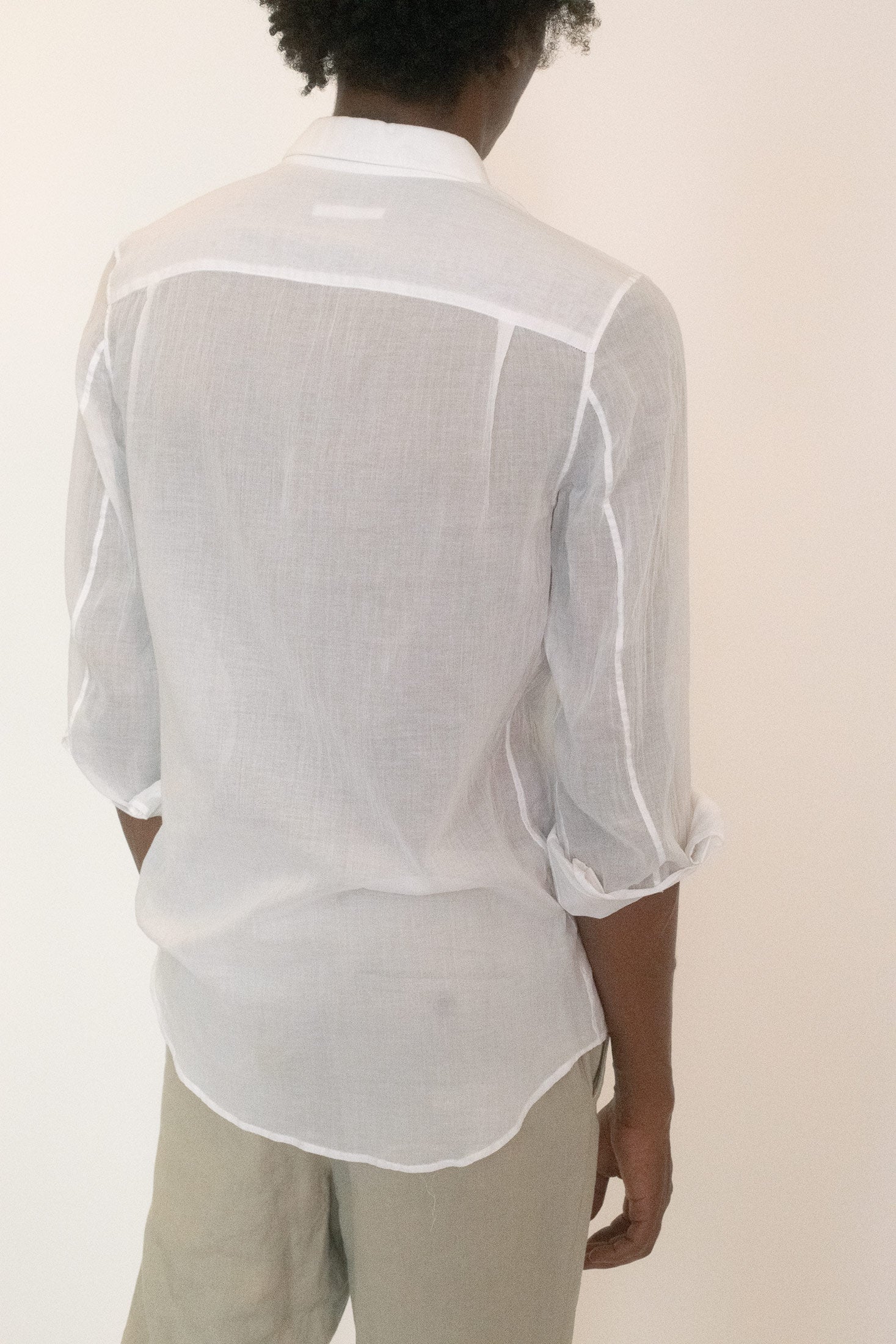 The sheerness creates tension with the traditional silhouette, lending the shirt to play between propriety and exposure.