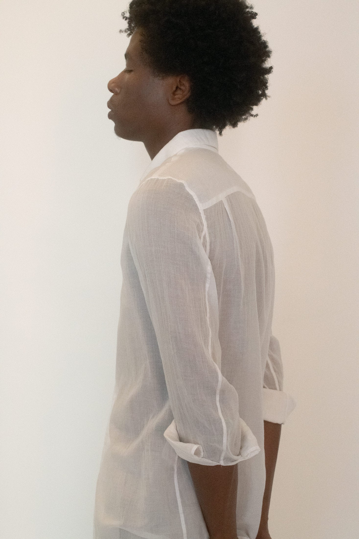 This Helmut Lang button down arrives in crisp white, its surface cut through with a whisper of transparency in the lightweight, semi-sheer fabric.