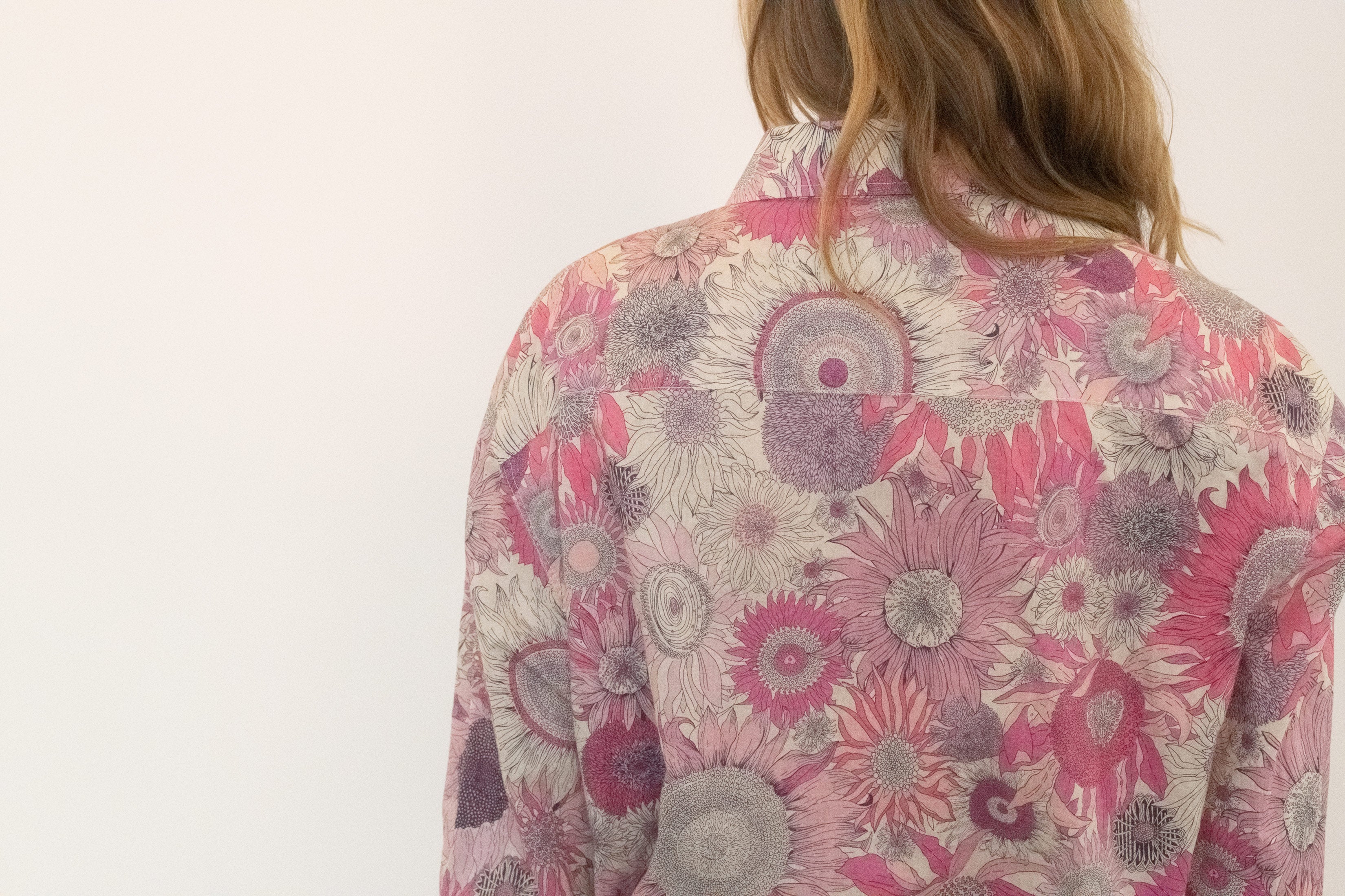 The fabric shifts with movement, catching light in a way that makes it less about flowers and more about atmosphere.