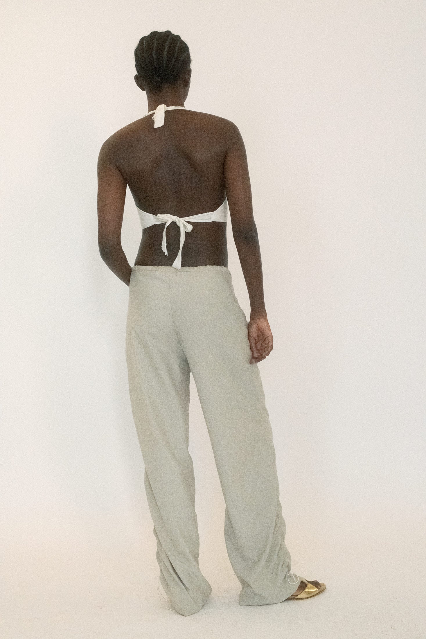 These pants feature an exposed elastic waistband that doesn’t just hold but gathers, running up the leg to create a ruched effect like tension pulled tight.