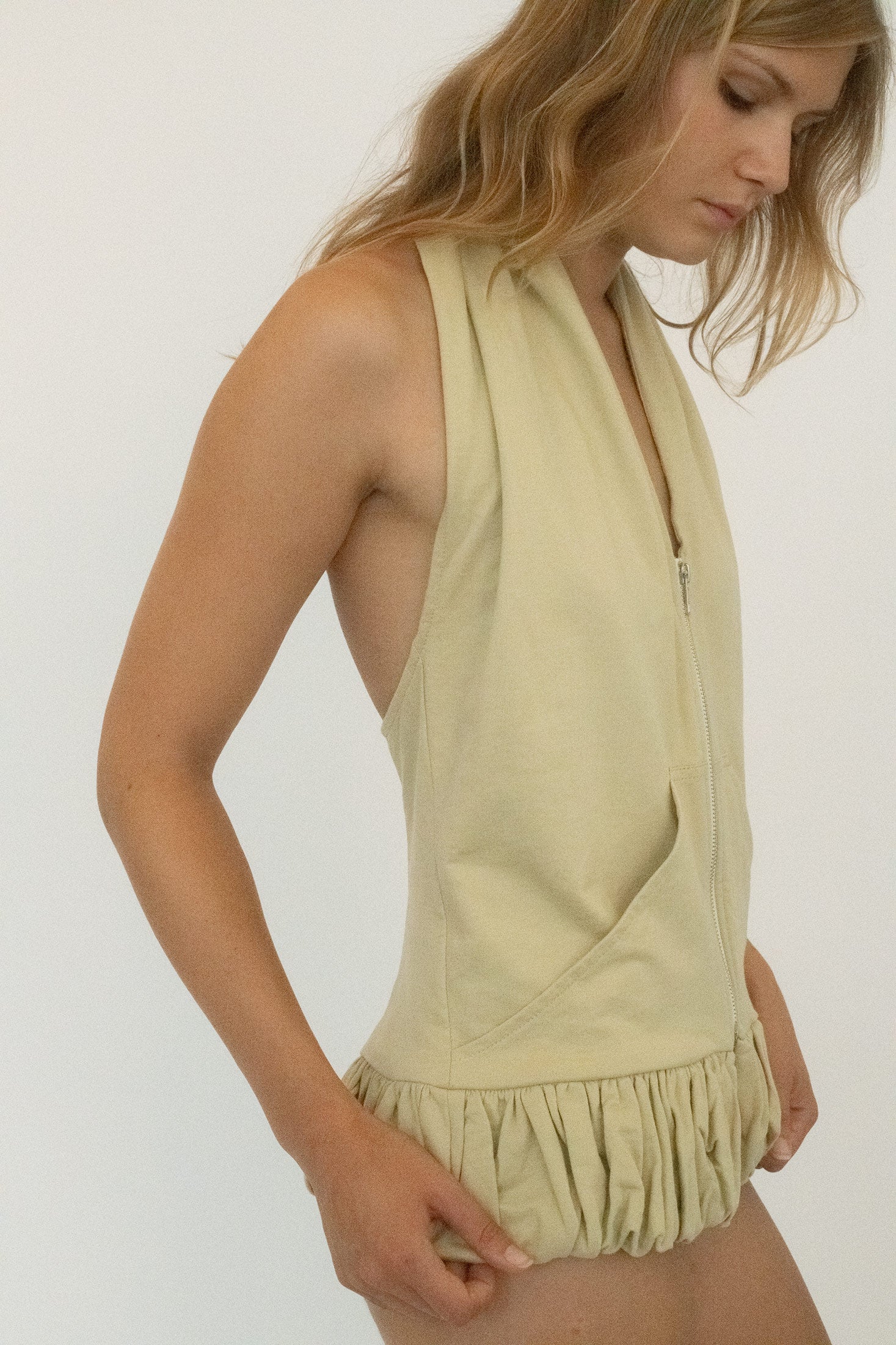 An exposed zipper runs down the center front, breaking the line with a flash of utility turned seduction.