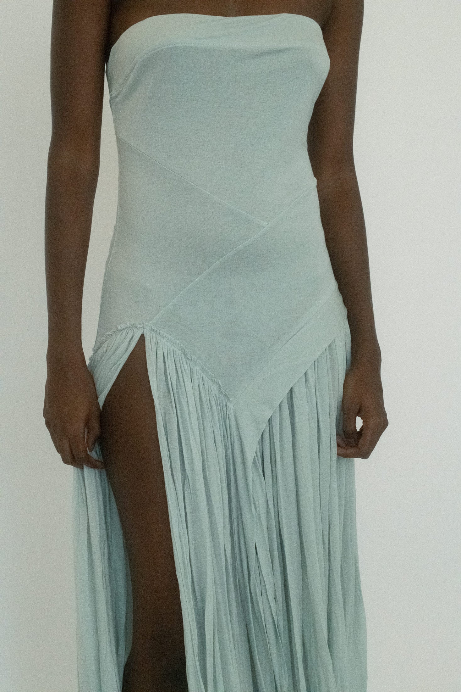 Cut strapless in a cool ice blue, it’s mapped with asymmetric seams that draw the eye in unexpected directions.
