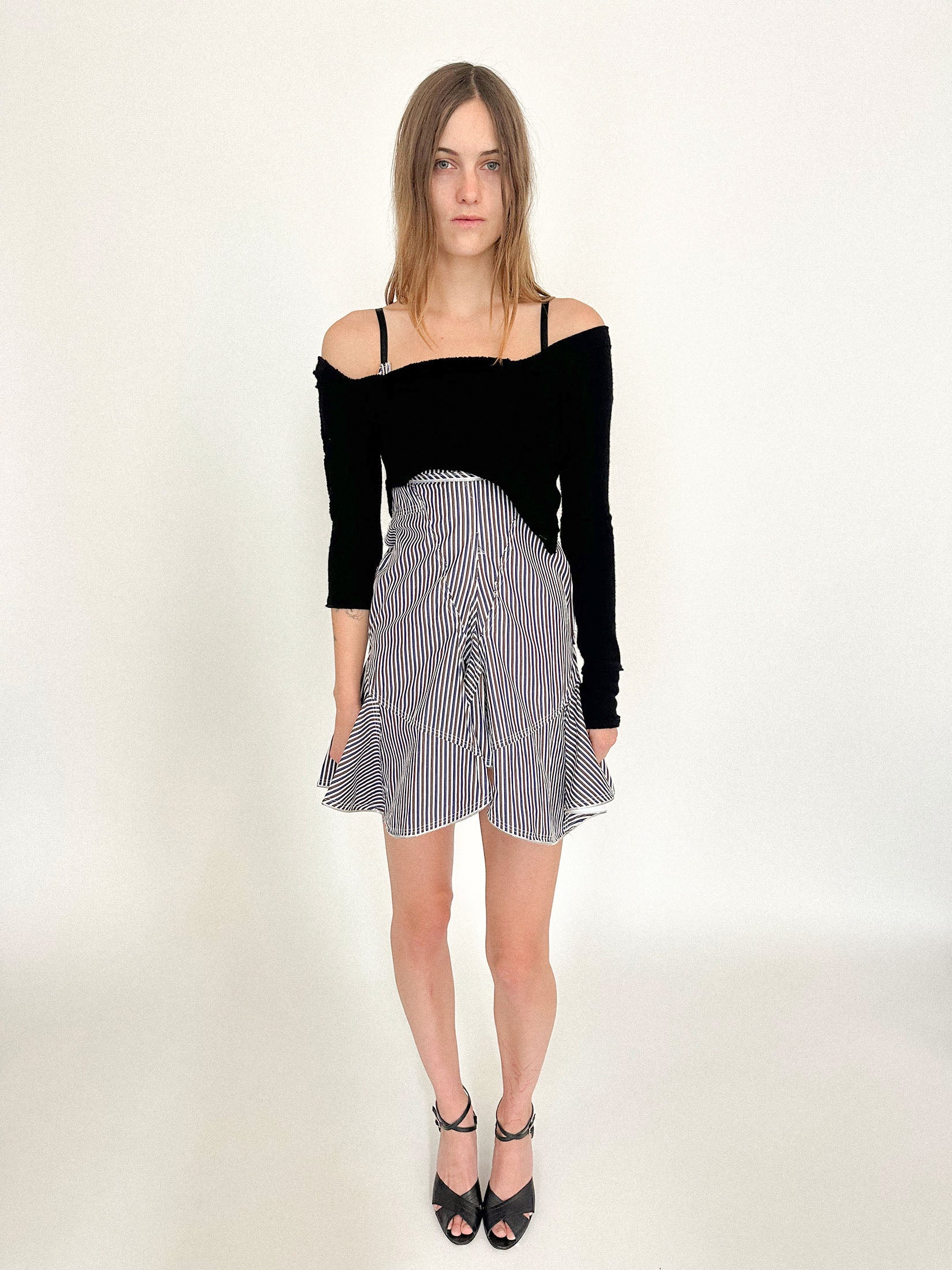 The asymmetrical sleeves shift the balance, creating a rhythm that feels both off-kilter and intentional.