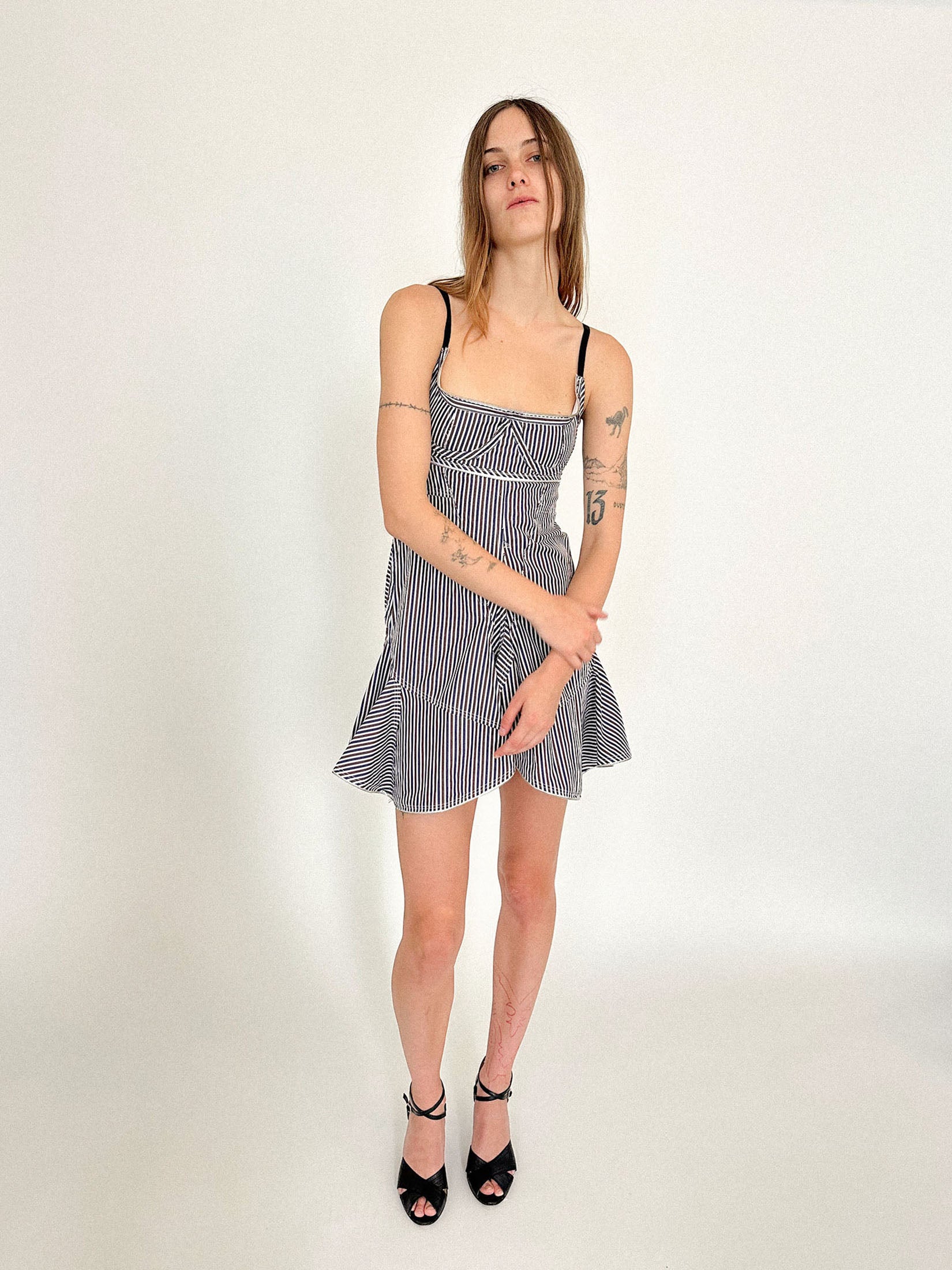 The bustier bodice shapes the frame with underwire cups and thin black straps, adjustable like lingerie. 