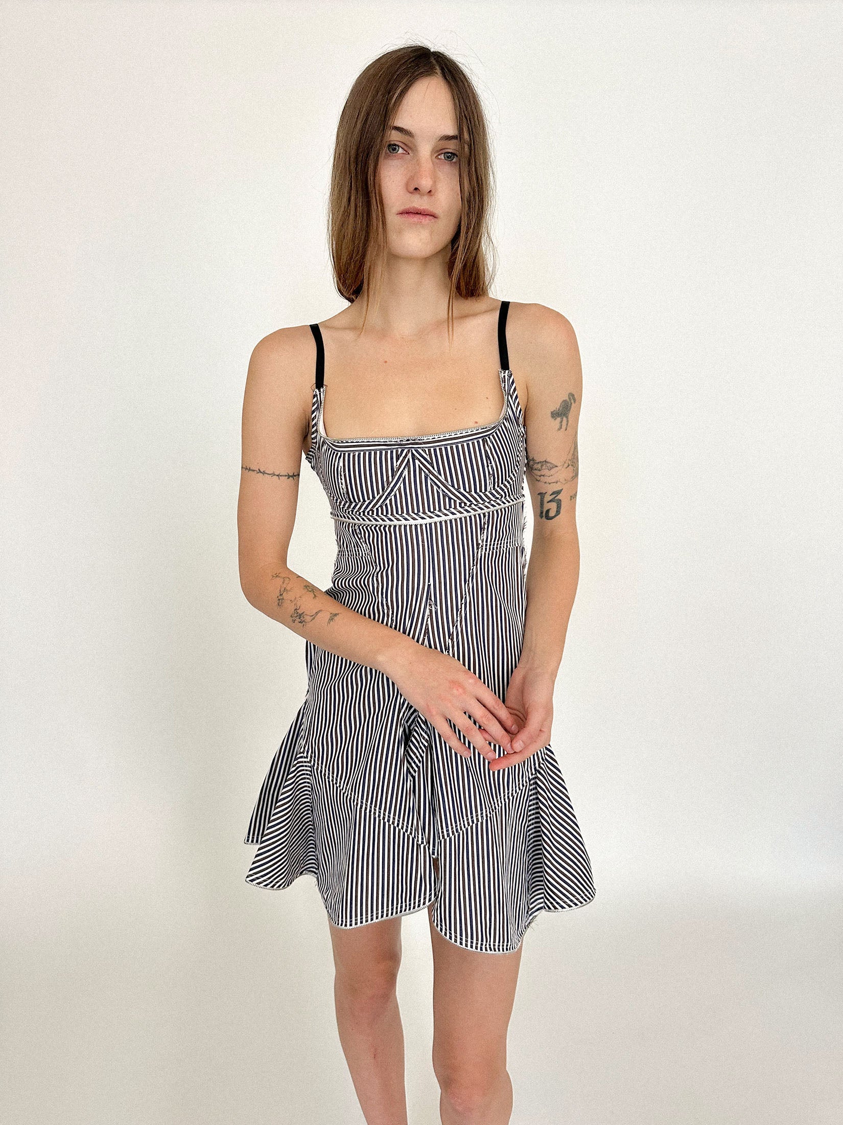 A pinstripe dress by Talia Byre, cut from cotton poplin and charged with quiet intent.