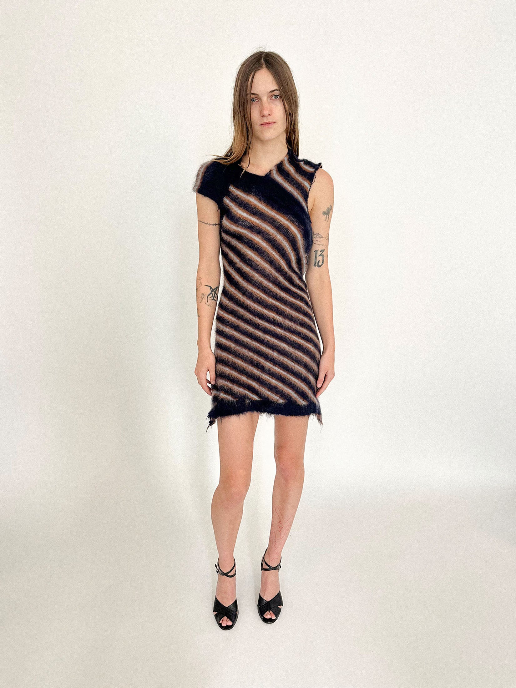 The V-neckline opens the front with quiet intent, while cap sleeves lend a touch of innocence that doesn’t quite last.