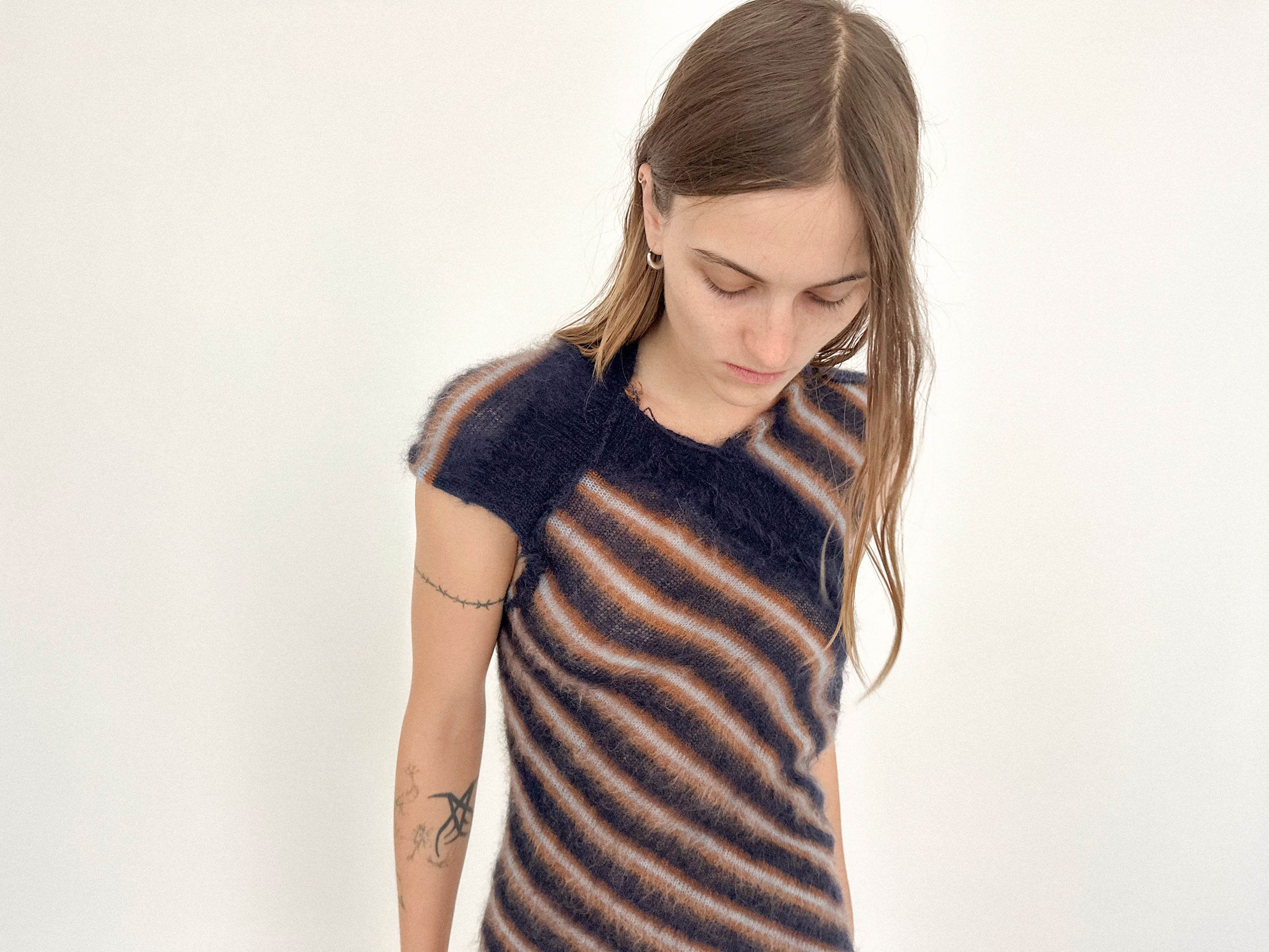 At the back, the twist reveals more than it hides - an open shape that turns restraint into theater.