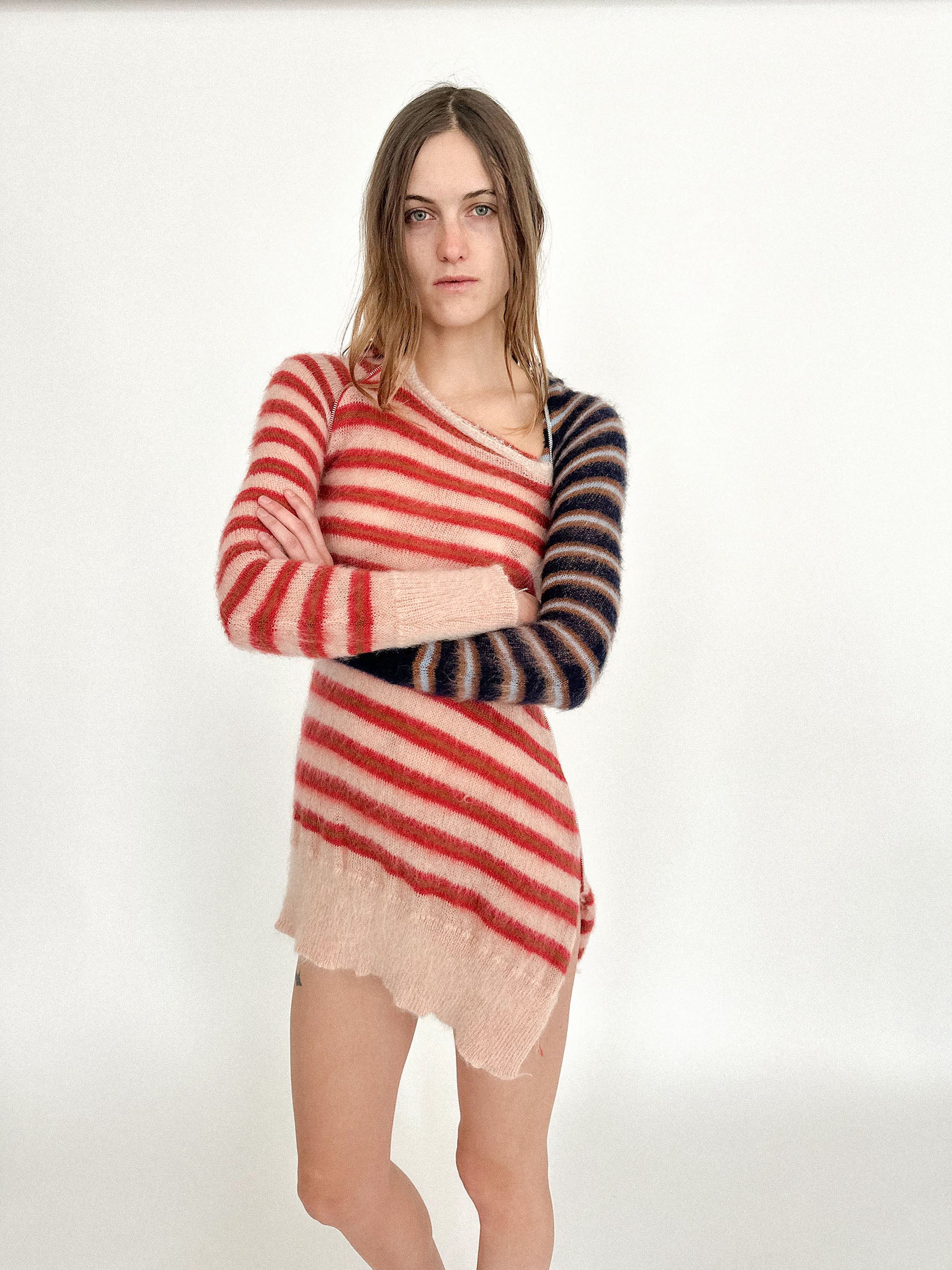 The hood adds a note of anonymity, cinematic and strange, while the clash of stripes keeps it from ever feeling polite.