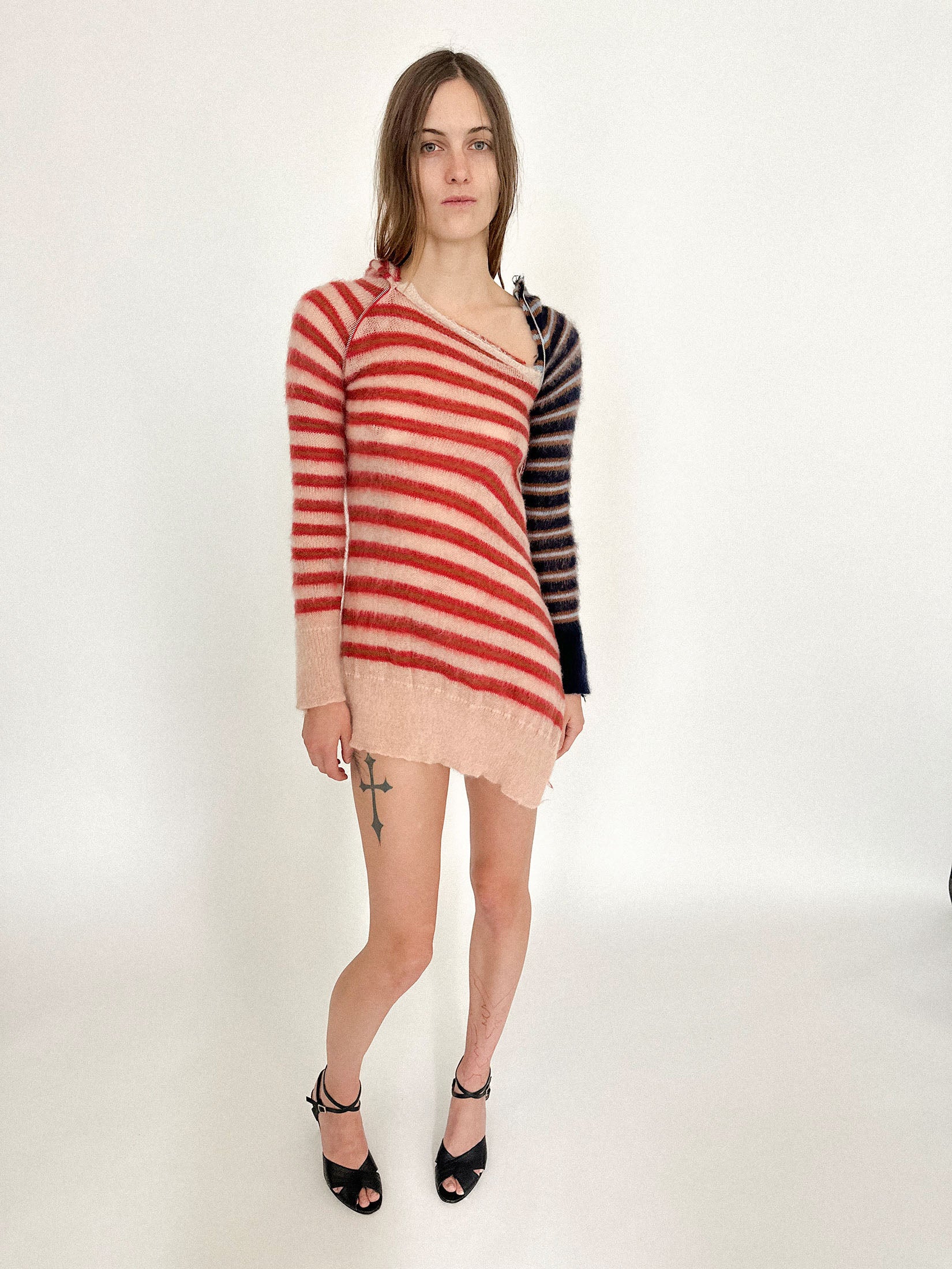 The knit drapes with a softness that disguises its tension, hovering somewhere between comfort and costume.