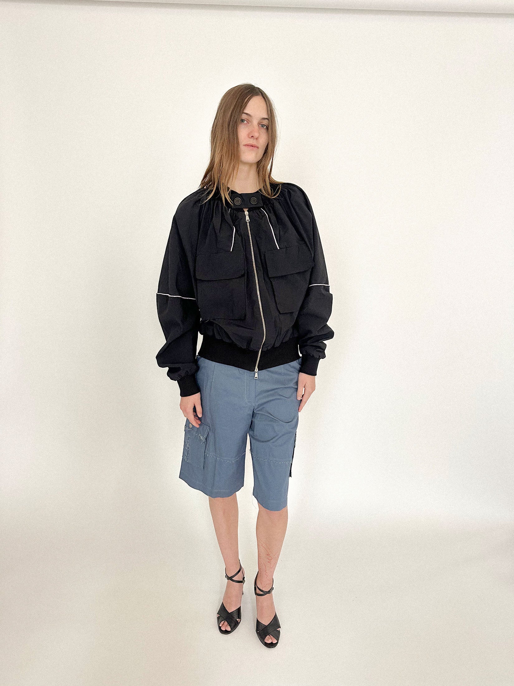 Elasticated cuffs and front pockets ground the form, keeping all the drama in check.
