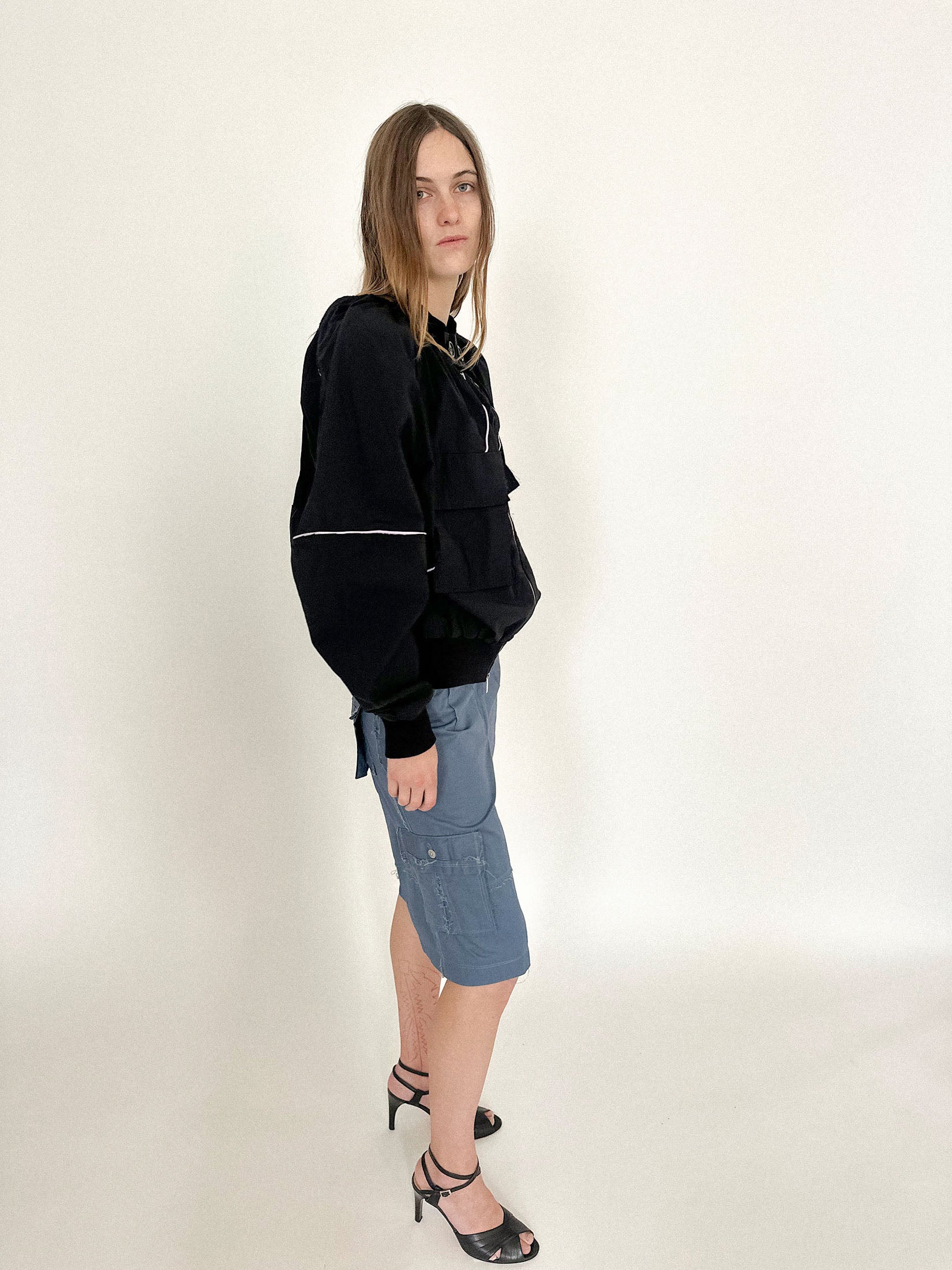 A button detail at the neck meets a double zip that runs both ways - functional, but far from neutral.