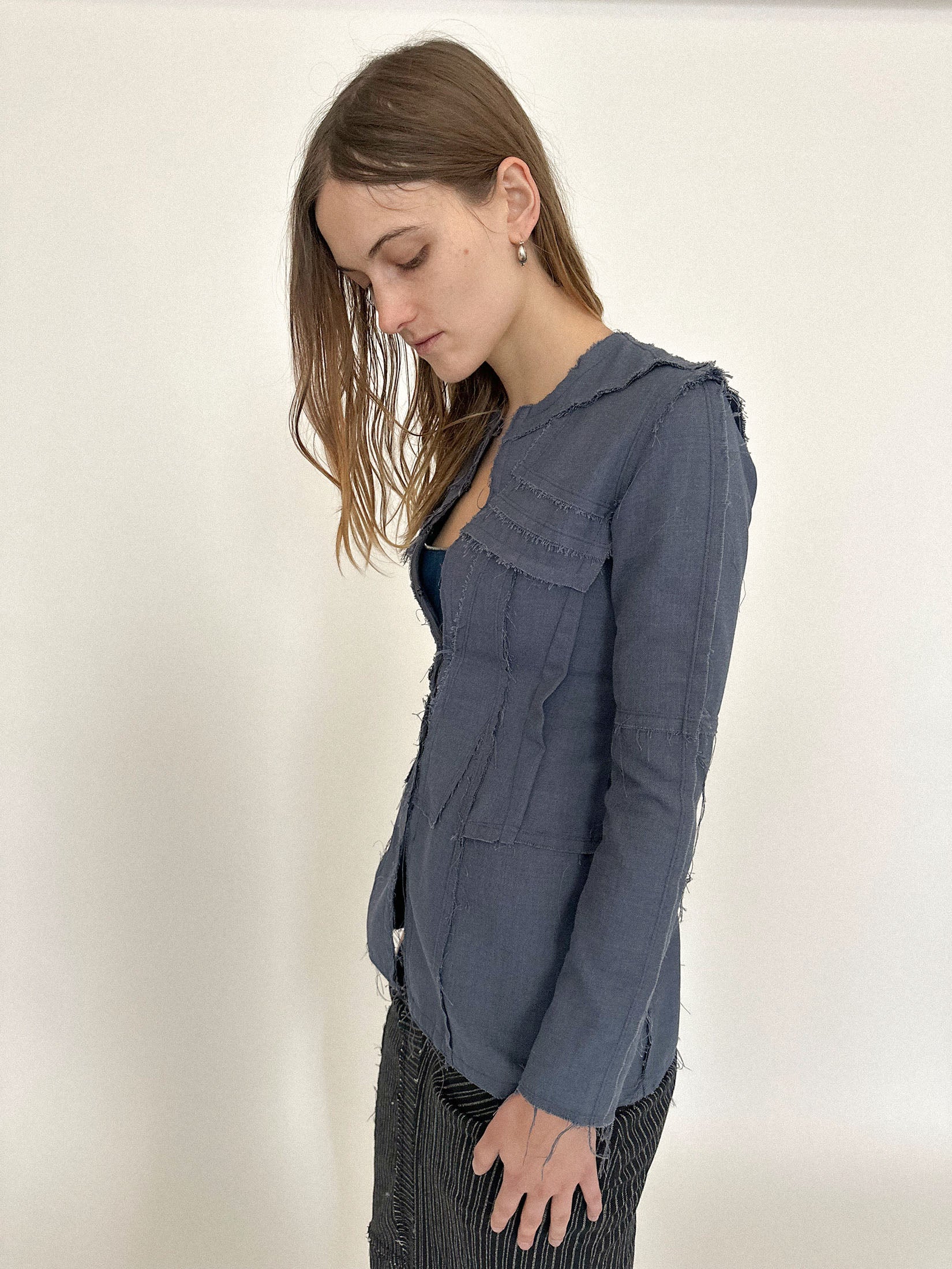 The hook-and-eye closure draws the front together just enough to suggest structure, never surrender.
