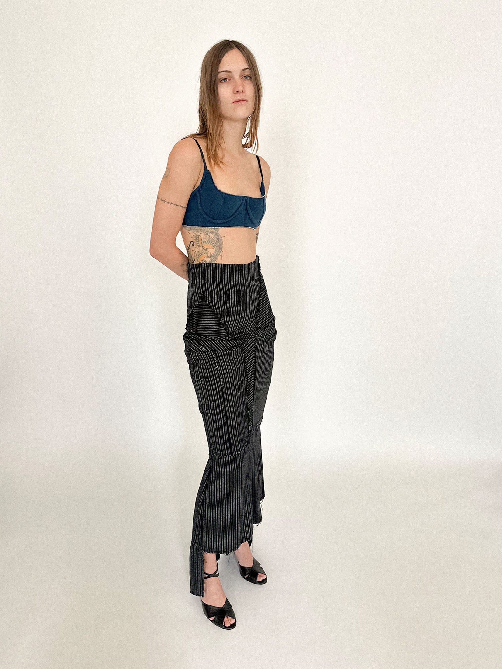 A black pinstripe skirt by Talia Byre, tailored with precision and an undertone of quiet defiance.