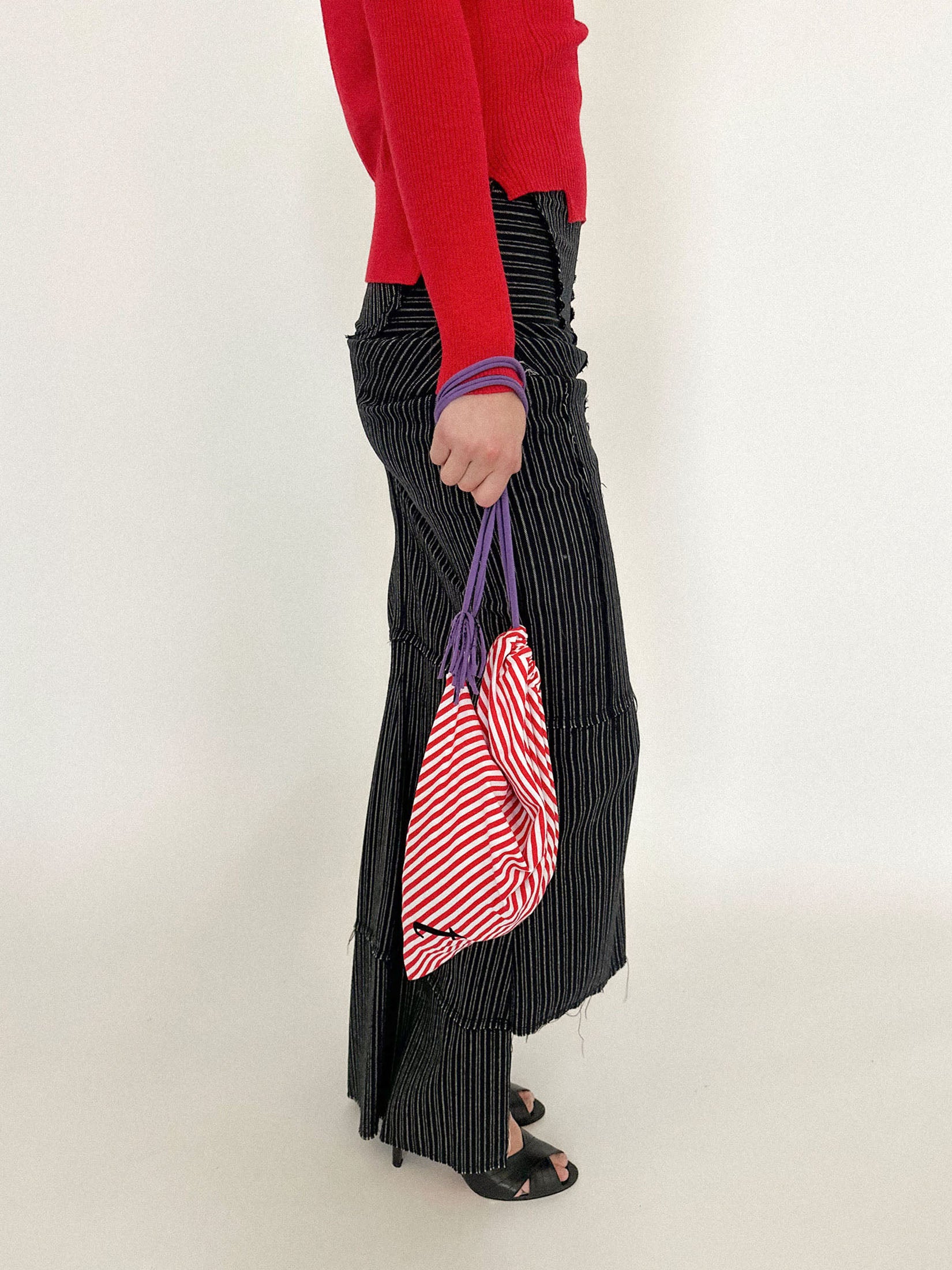 Tassel details hang loose at the ends, while a small logo sits quietly on one side, like a secret meant only for those who notice.